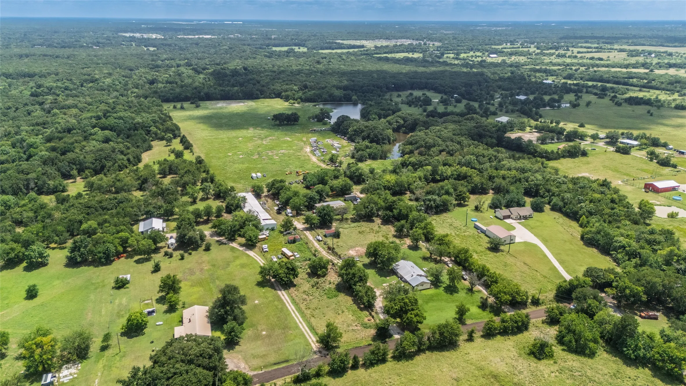 Expansive rural landscape featuring a mix of cleared pastures and mature tree lines