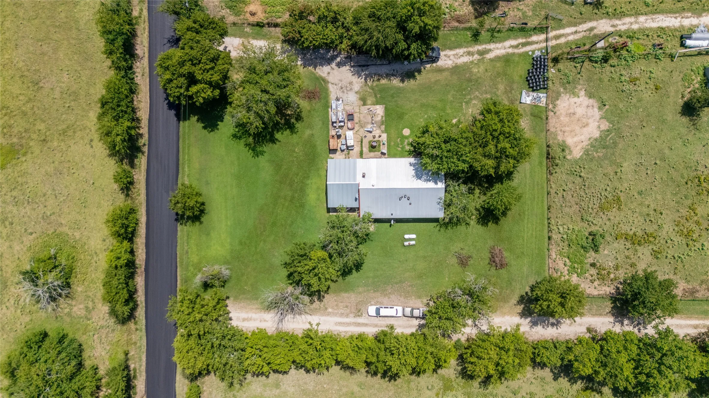 Expansive lot with a central building featuring a light-colored roof