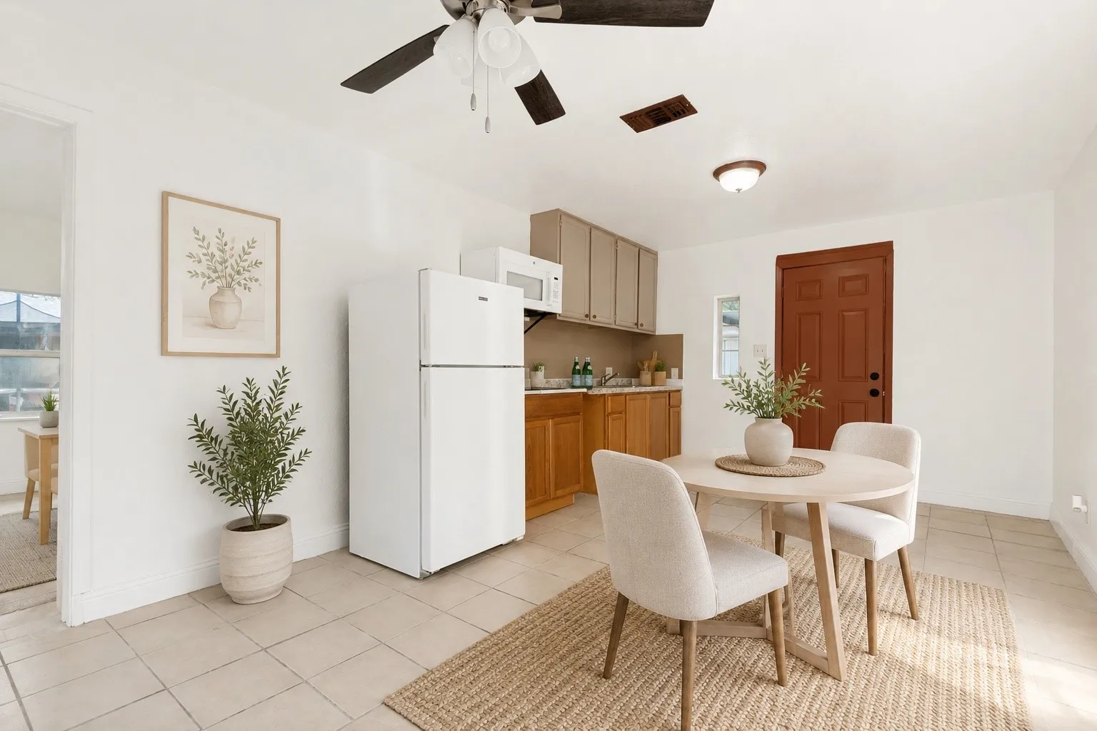 Kitchenette featuring ceramic tile flooring, a ceiling fan, wood-finish lower cabinetry, and light-toned upper cabinetry