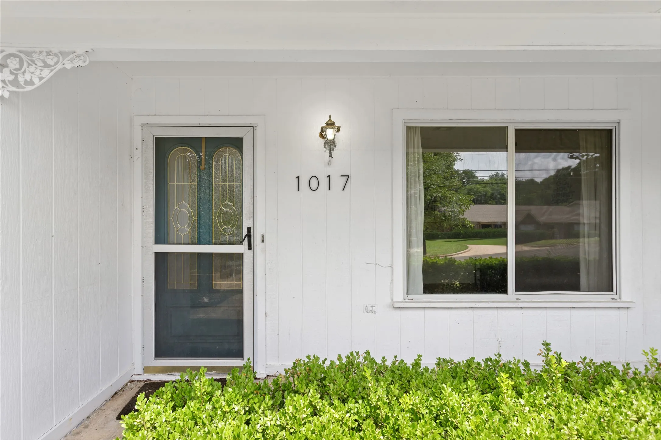 White vertical siding exterior with a decorative architectural bracket