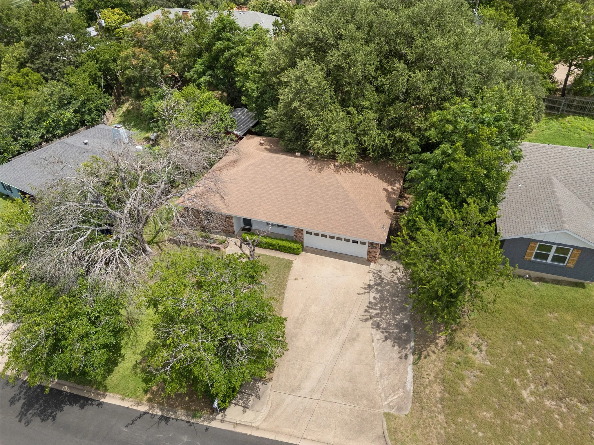 Ranch-style residence featuring a prominent brown shingle roof and an attached two-car garage