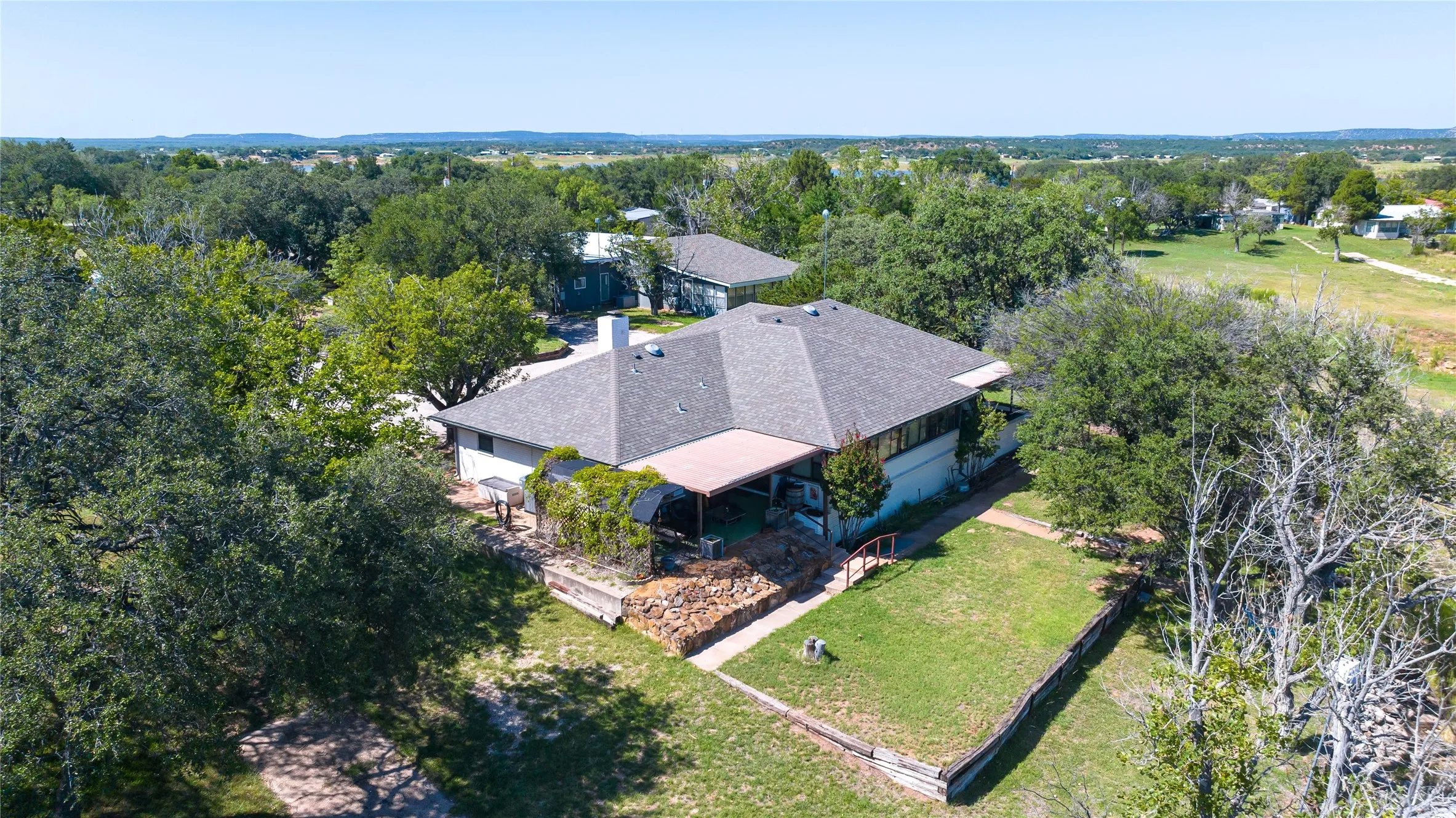 Expansive property featuring a multi-gabled roofline, a covered patio area, and a prominent chimney