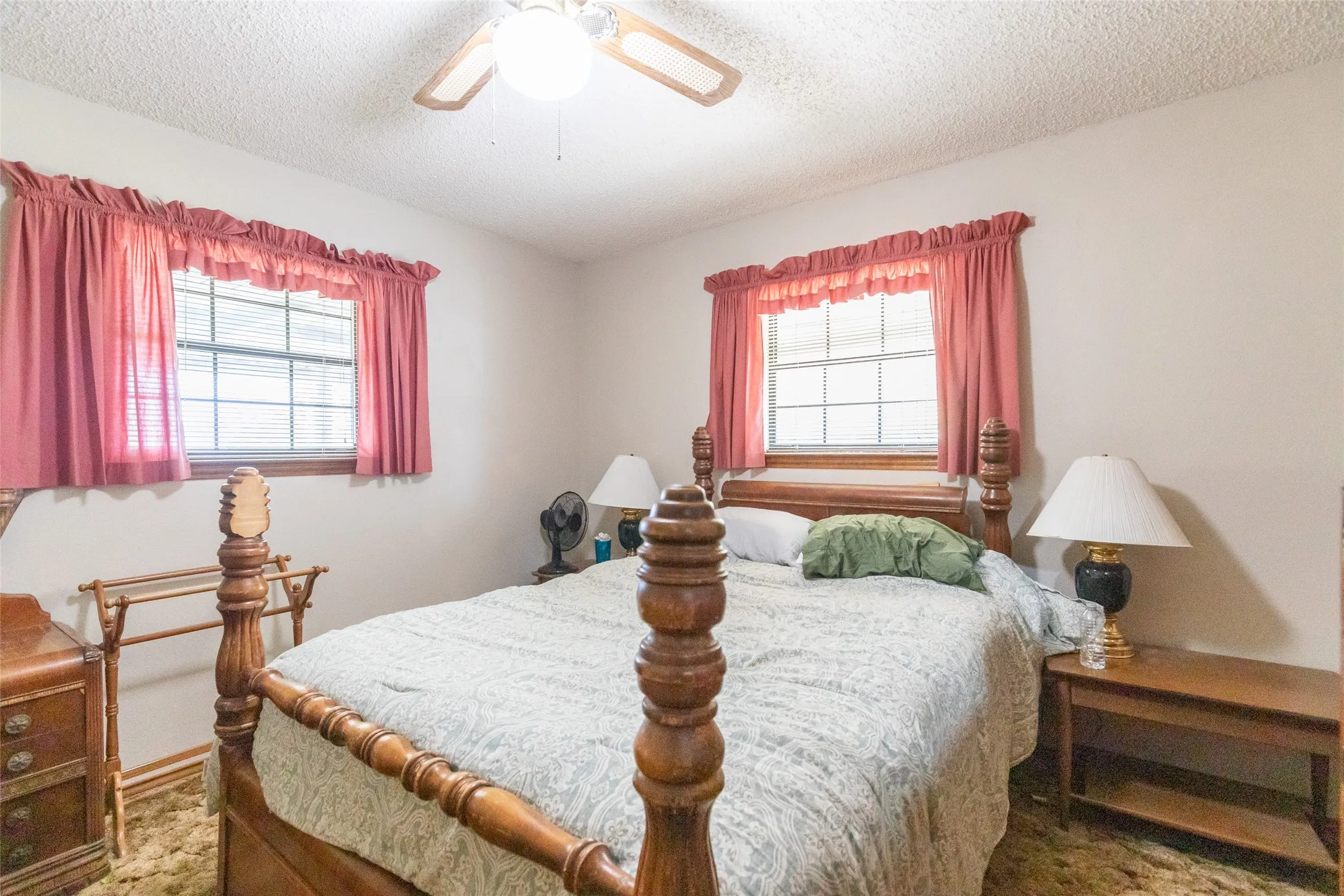 Interior room with two windows, a ceiling fan, and carpeted flooring
