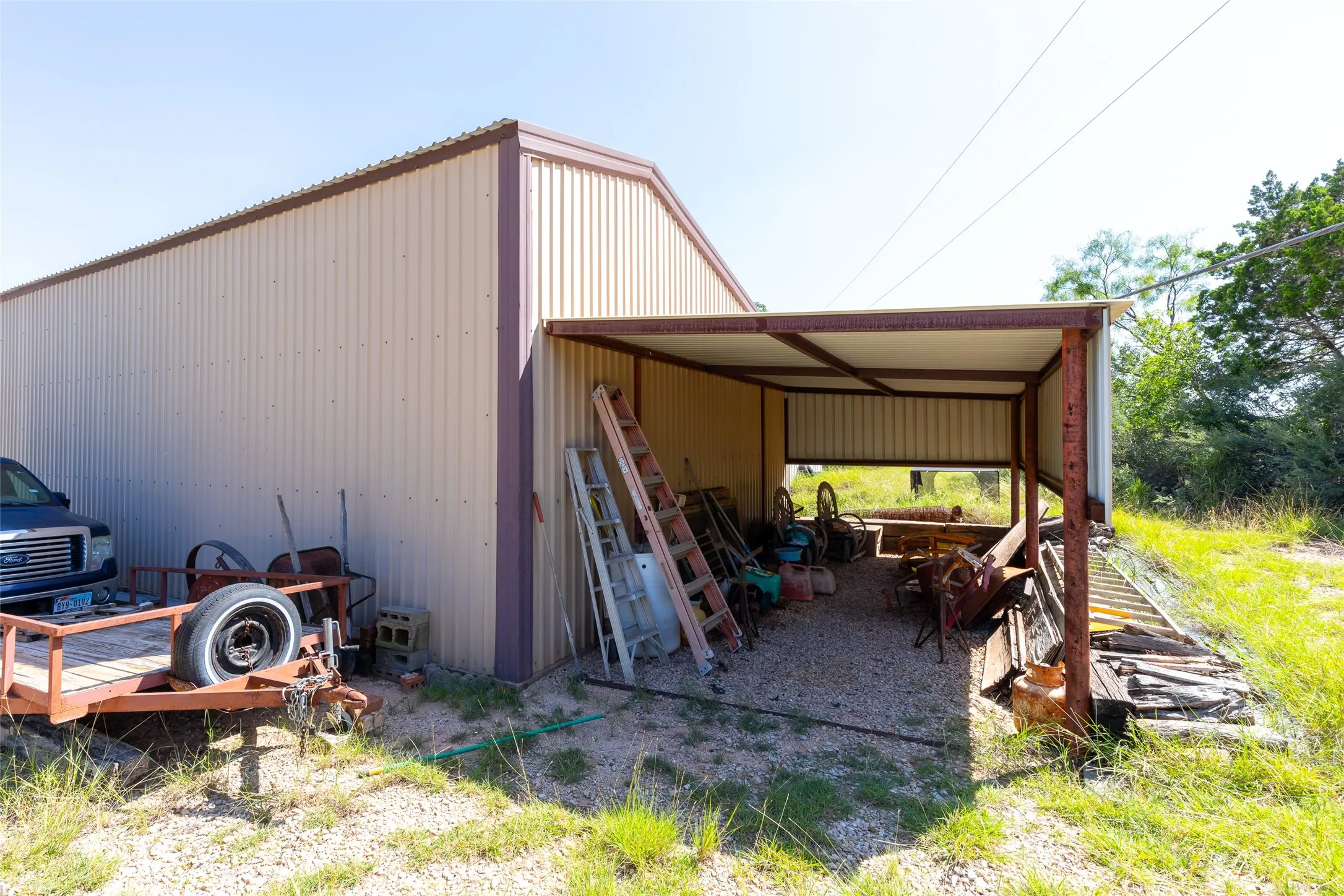 Corrugated metal outbuilding with a covered open-air extension