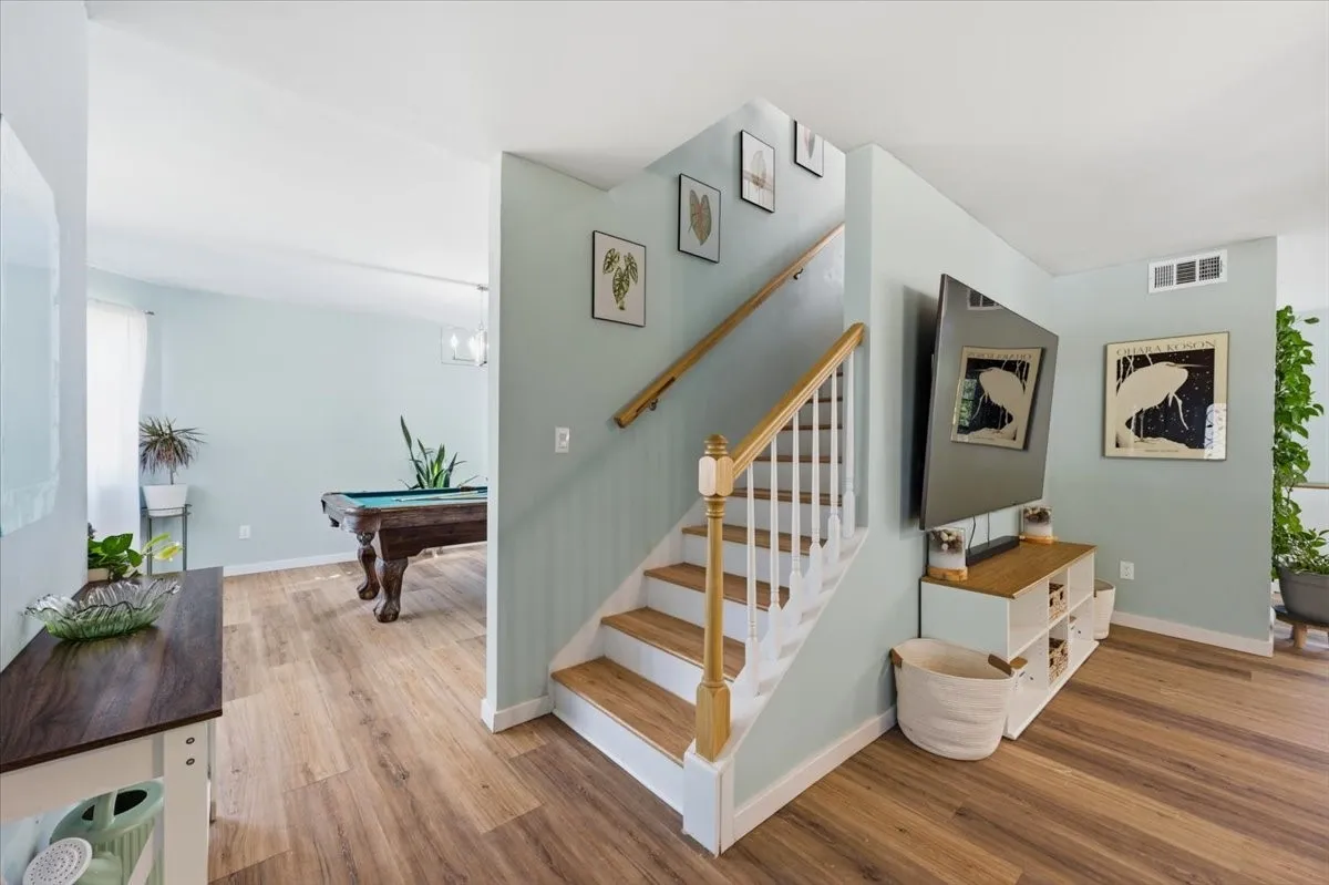 Interior staircase featuring wood-finish treads and a white balustrade