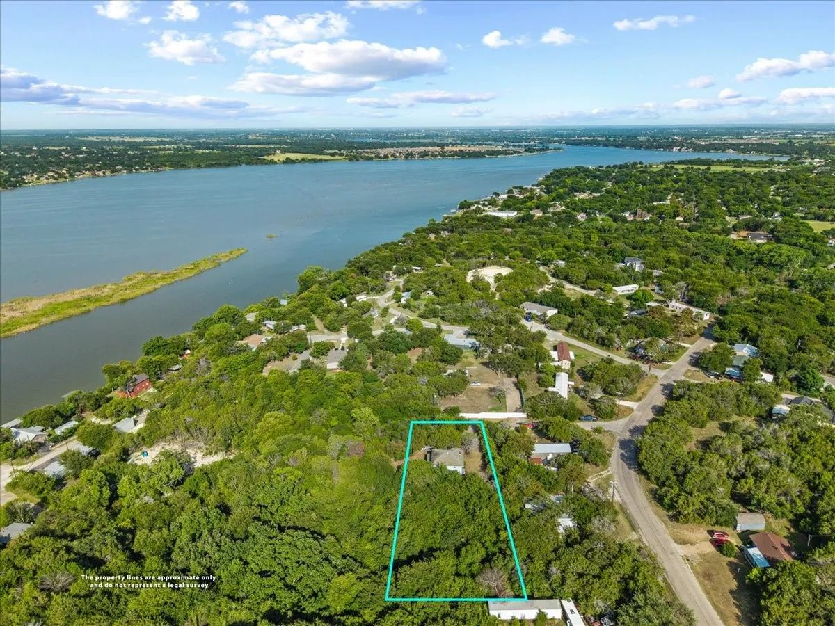 Aerial perspective showcasing a property surrounded by mature trees, situated within a green landscape