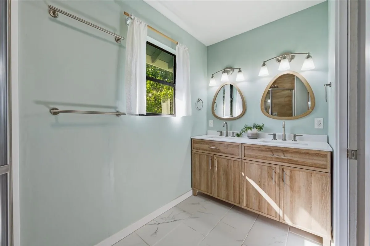 Dual vanity featuring wood-finish cabinetry and white countertops