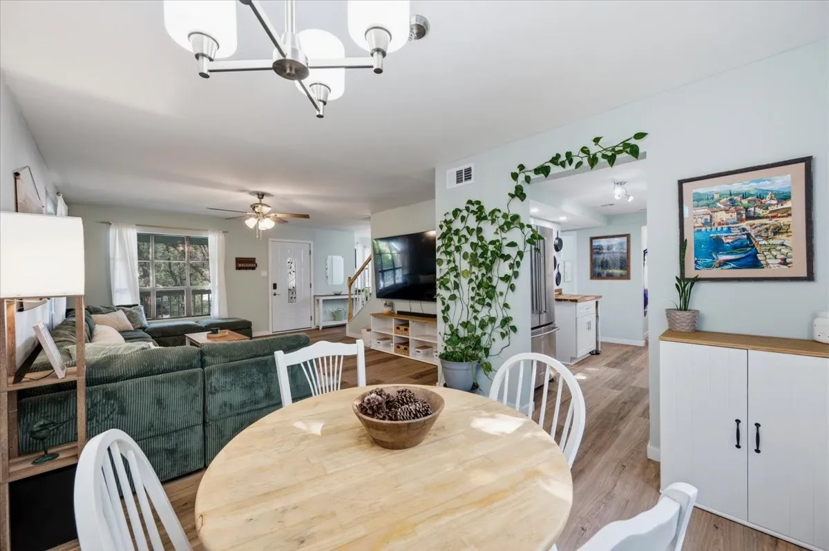 Open-concept living area featuring wood-finish flooring, a contemporary chandelier, recessed lighting, and a ceiling fan