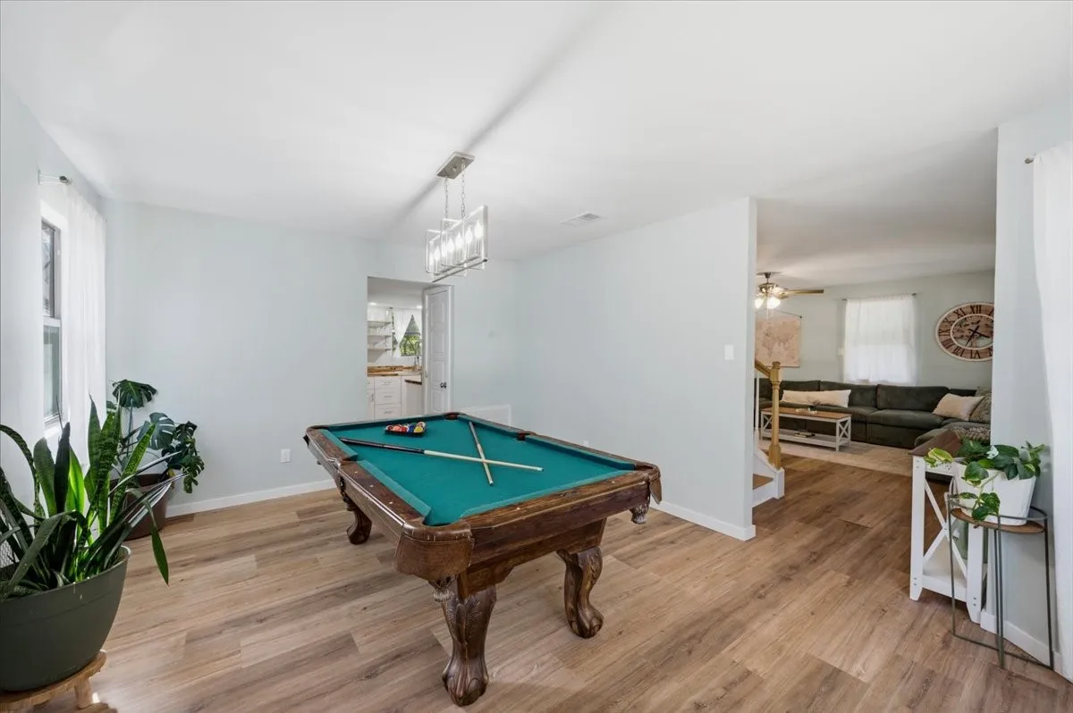 Spacious room featuring wood-finish flooring and light-toned walls