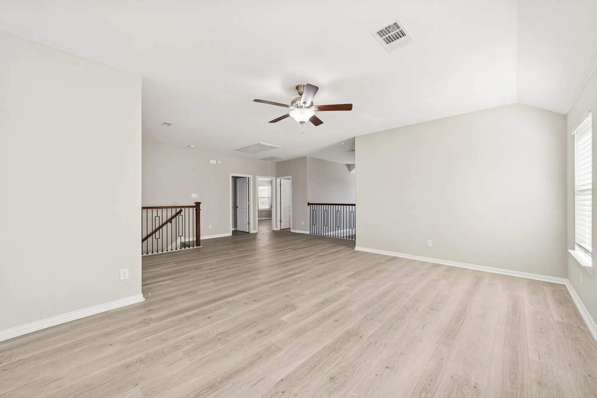 Open gameroom with a ceiling fan, and lofted ceiling