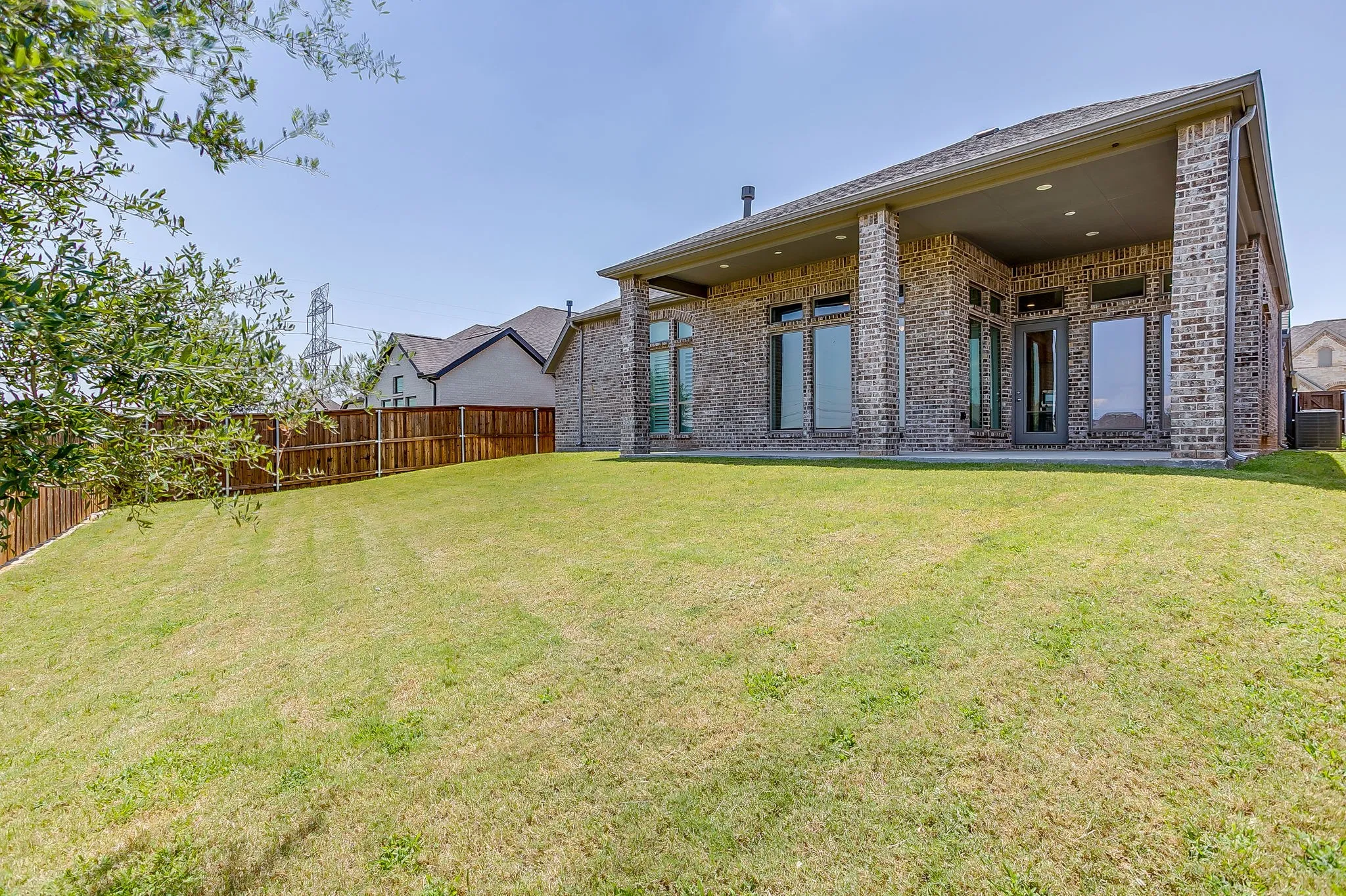 Expansive grassy area with a wood privacy fence