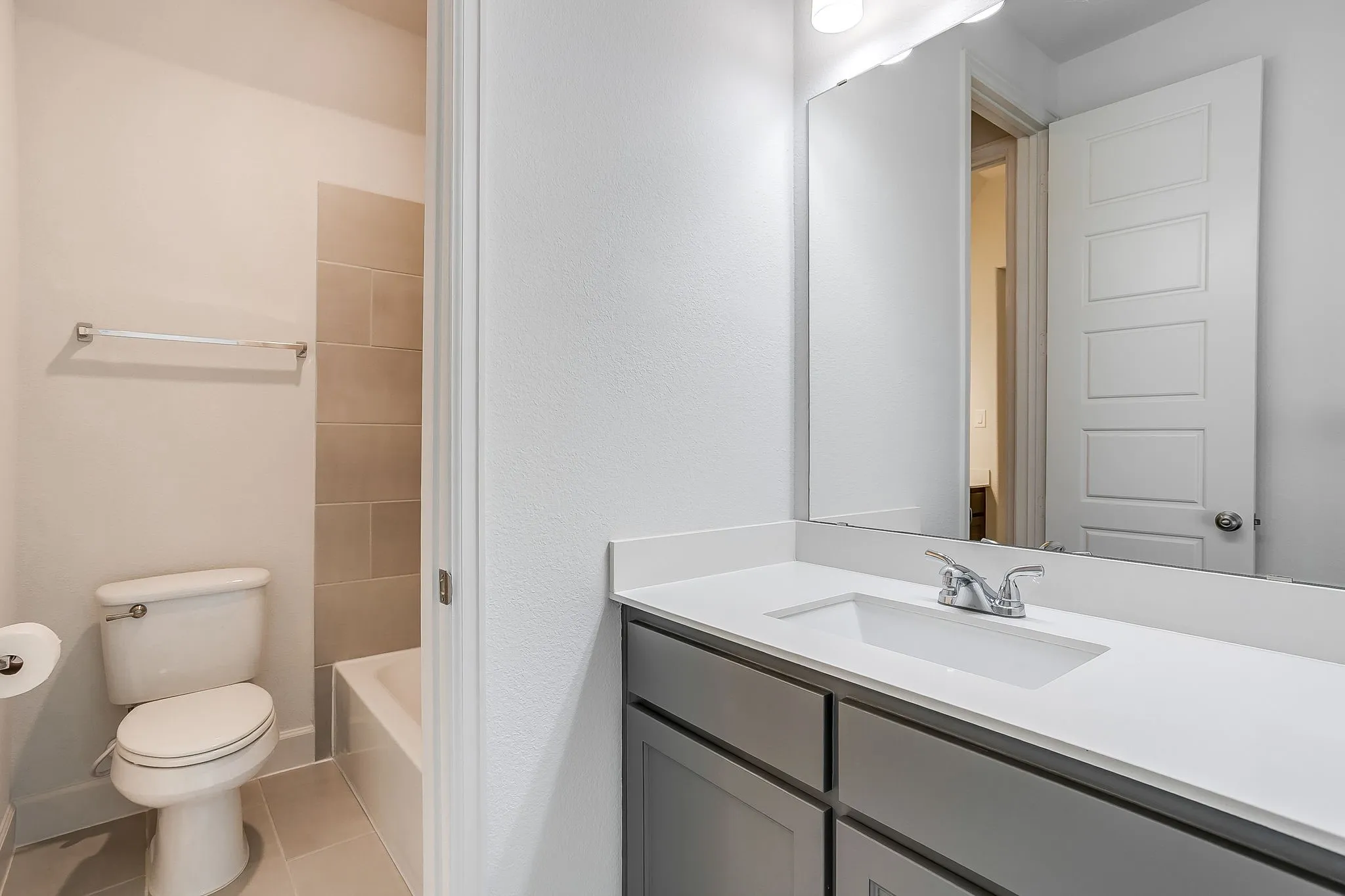 Bathroom featuring a single vanity with an integrated sink, polished chrome faucet, and ample under-counter storage