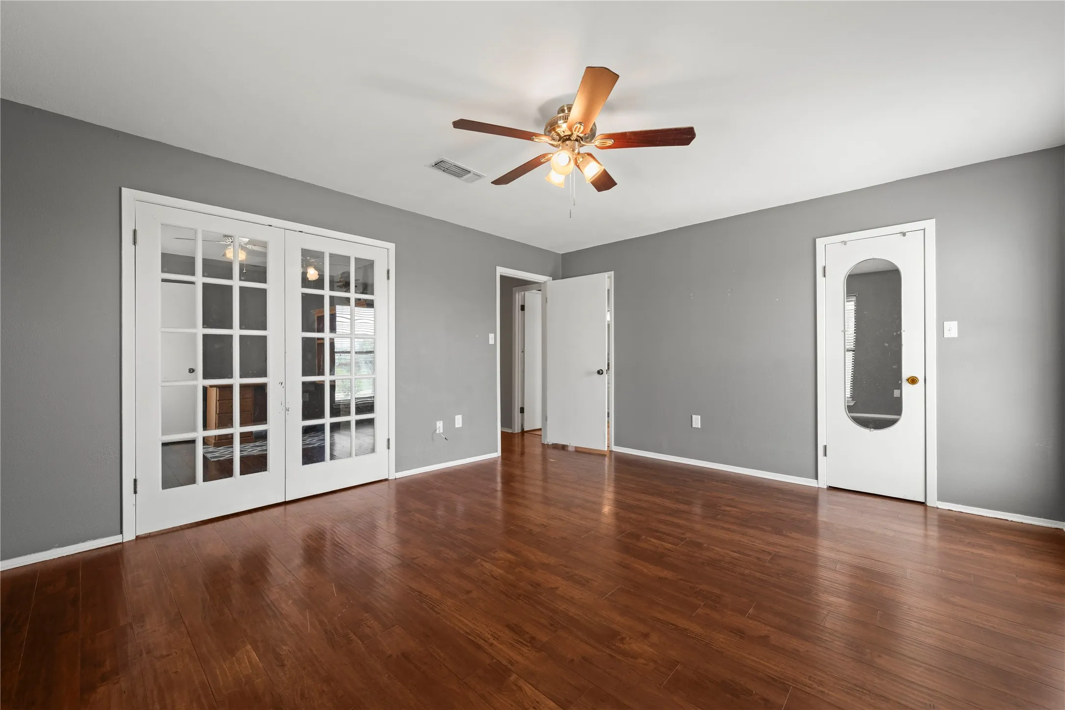 Generously sized primary suite featuring French doors, a private entrance, and direct access to the ensuite bathroom