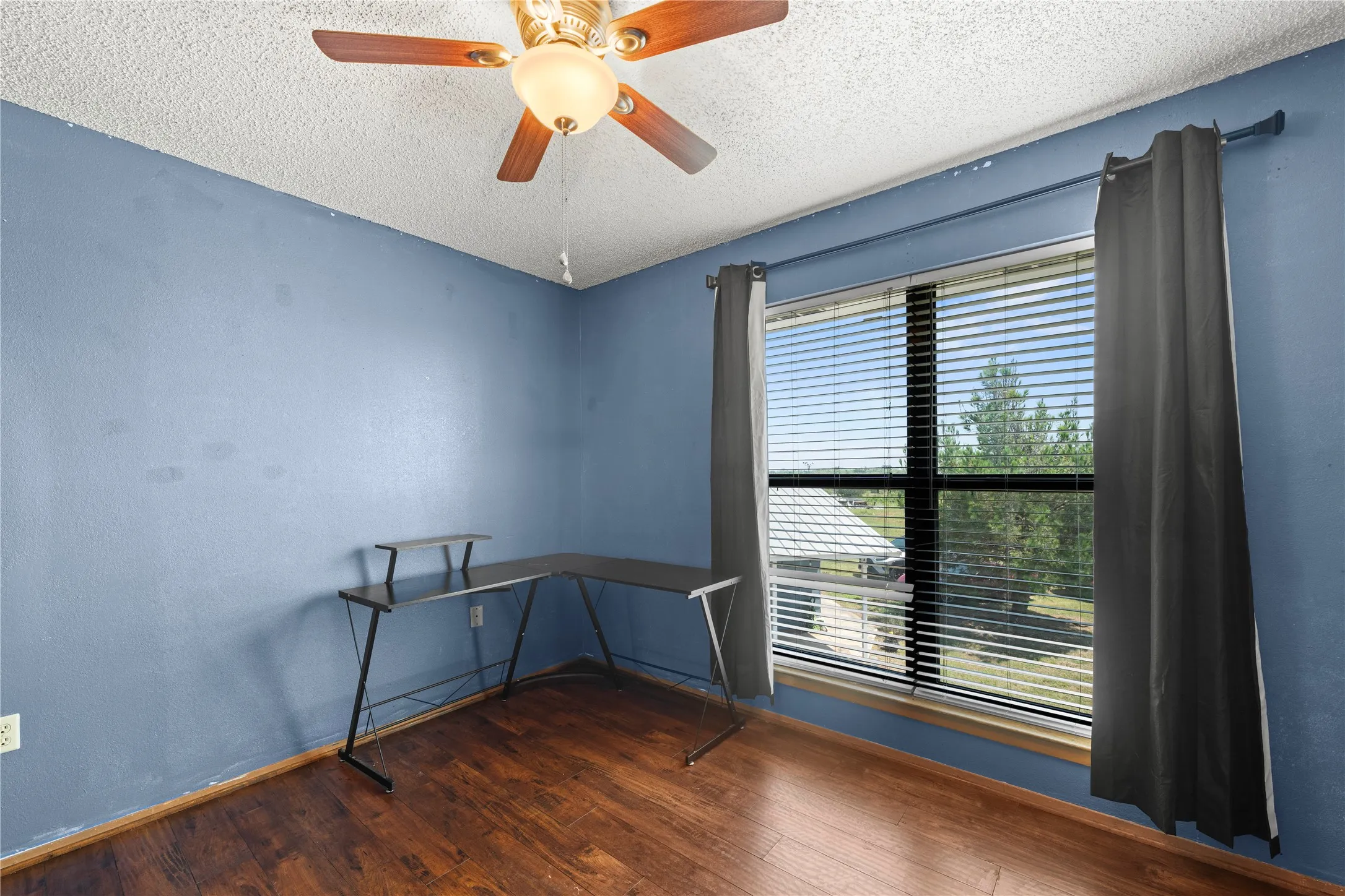 Bright guest bedroom with blue walls and large window view