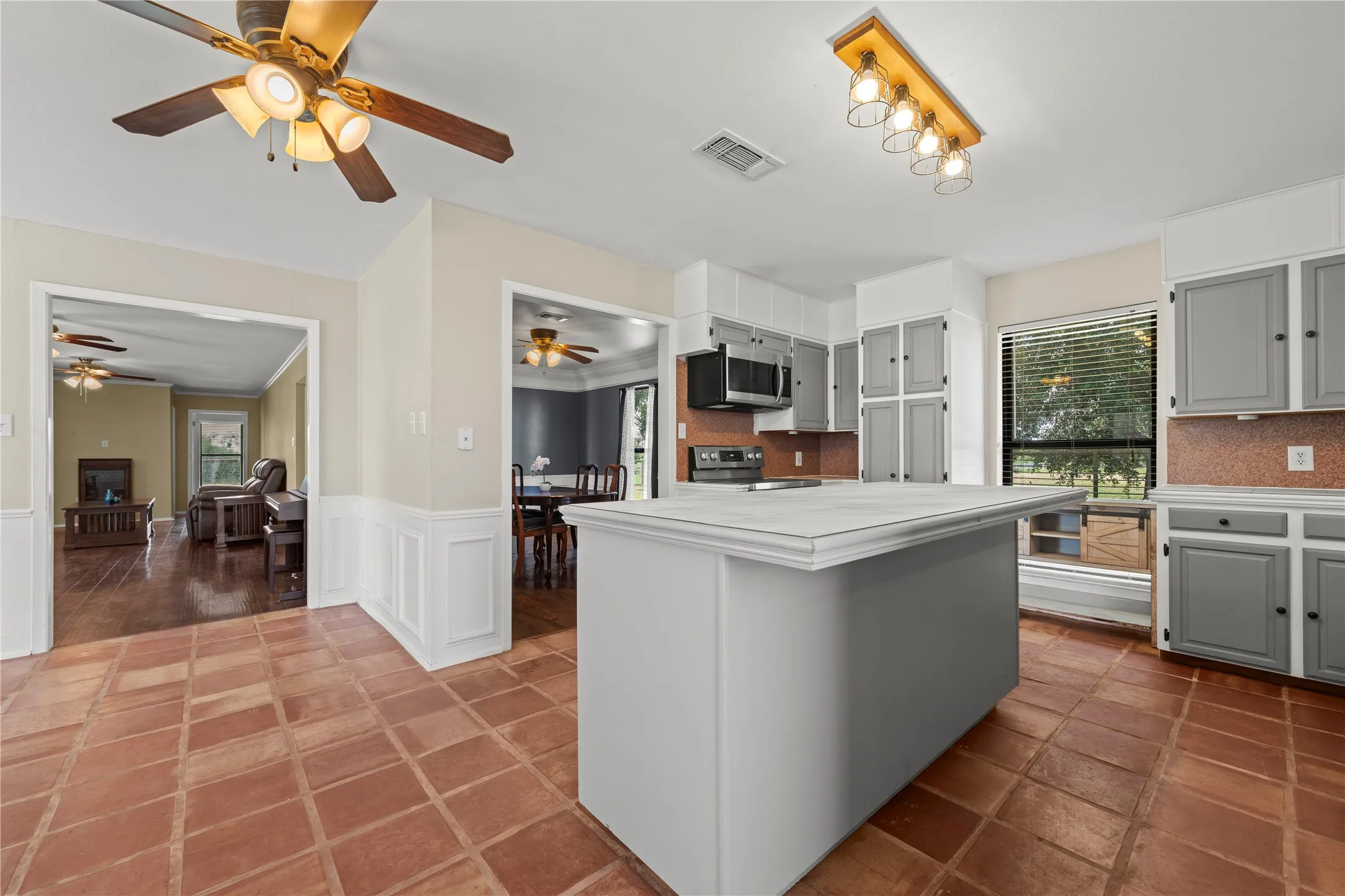 Functional kitchen layout featuring a tiled island, stainless range, and easy flow into the adjoining dining room.