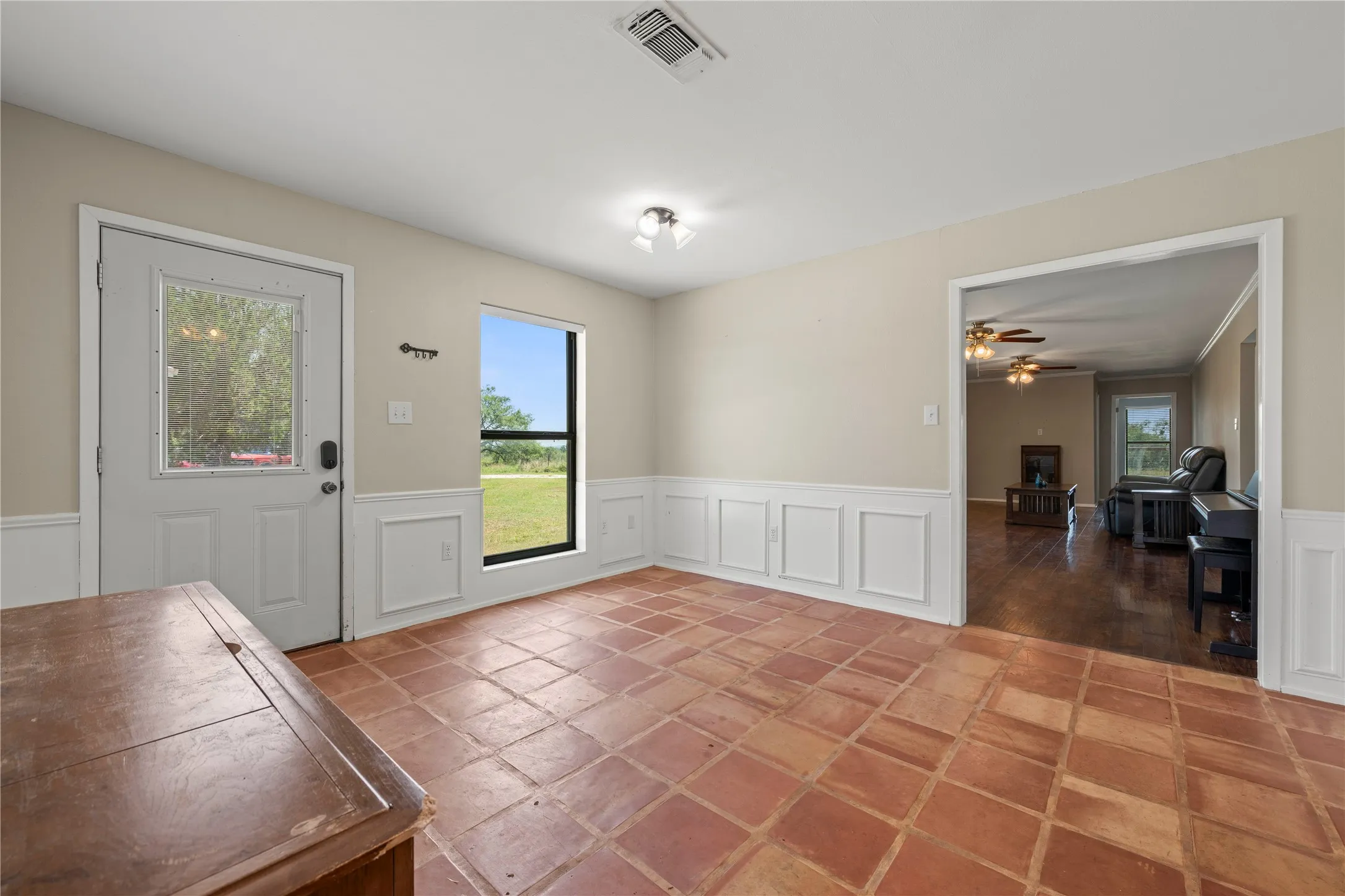 Bright breakfast area with Saltillo tile flooring and a private exterior door