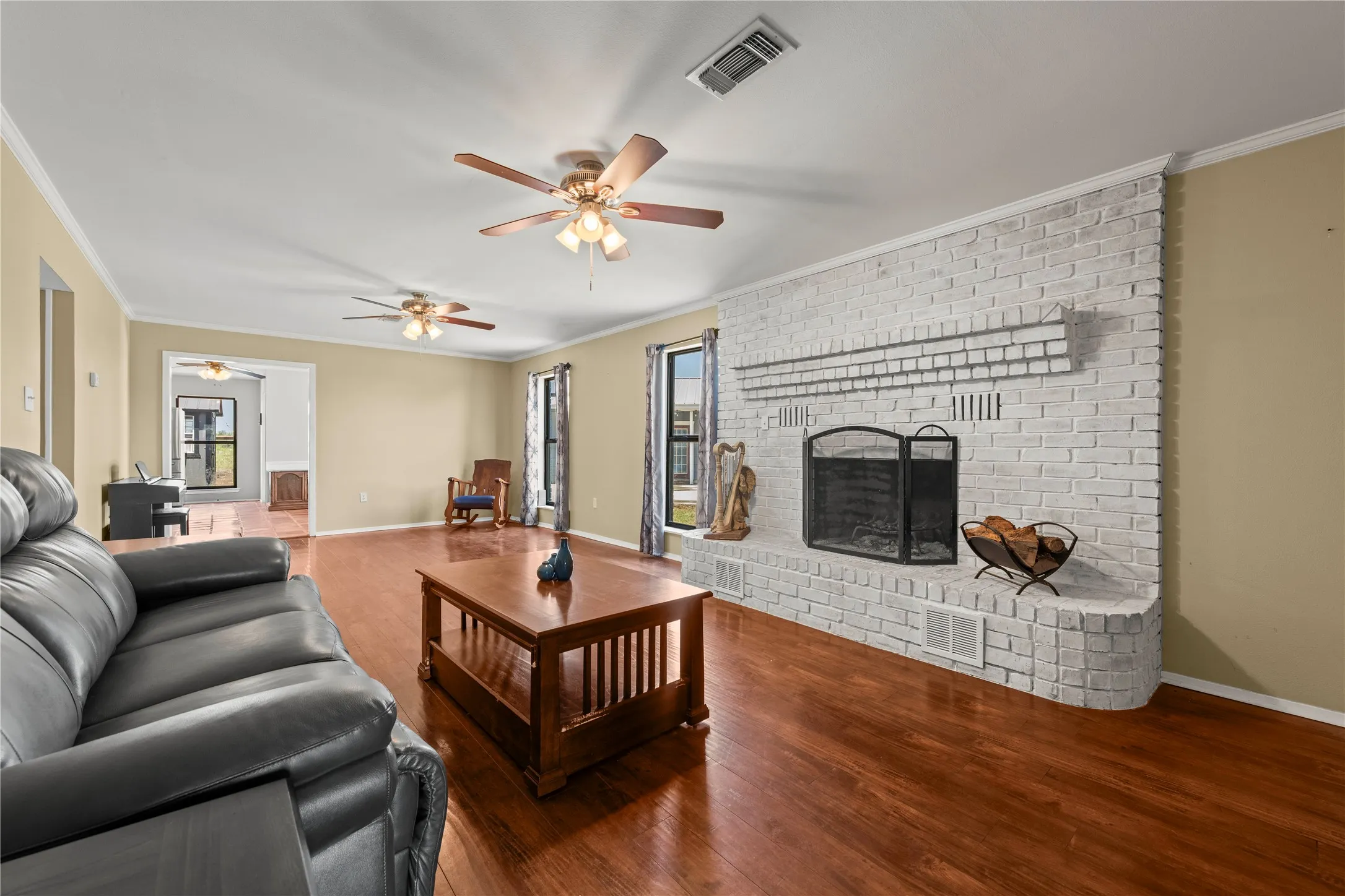 Cozy living room centered around a charming painted brick fireplace, perfect for gathering on cool Texas evenings.