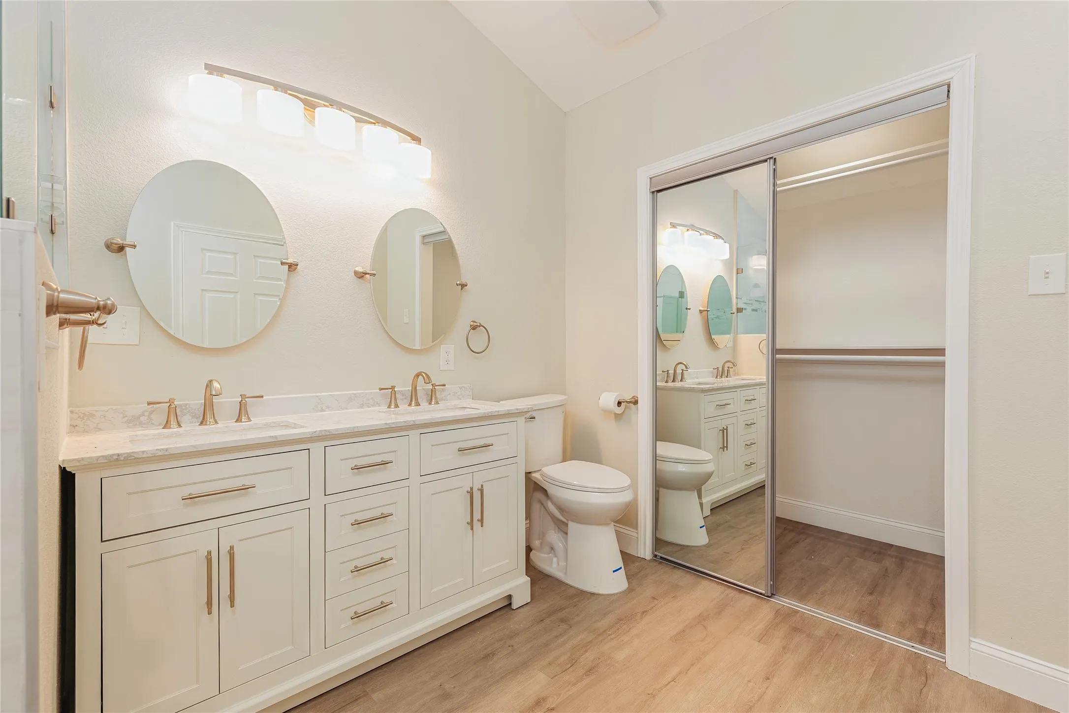 Dual vanity with white cabinetry, integrated sinks, and a stone-finish countertop