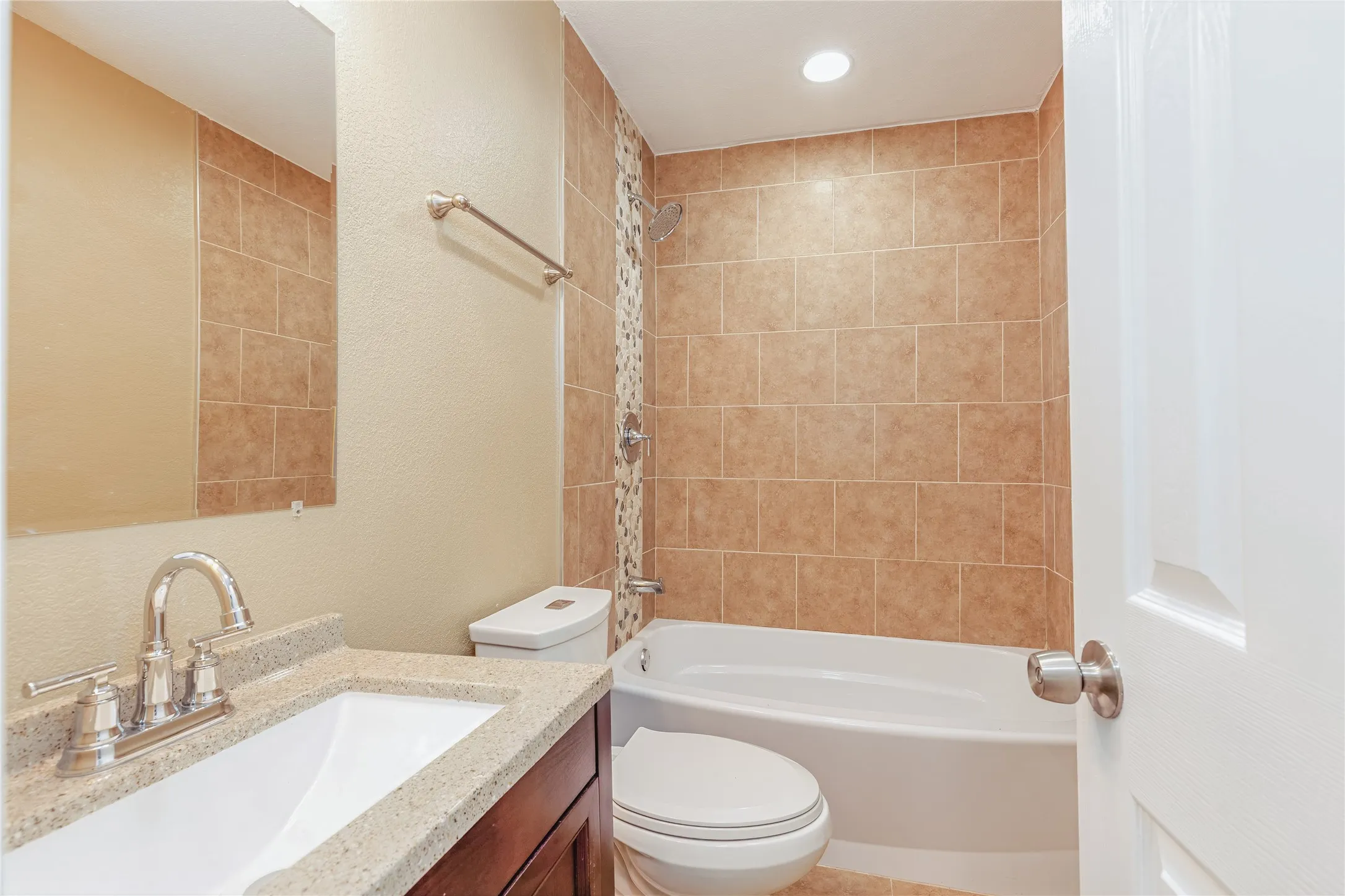 Built-in vanity with a polished countertop, undermount sink, and chrome faucet