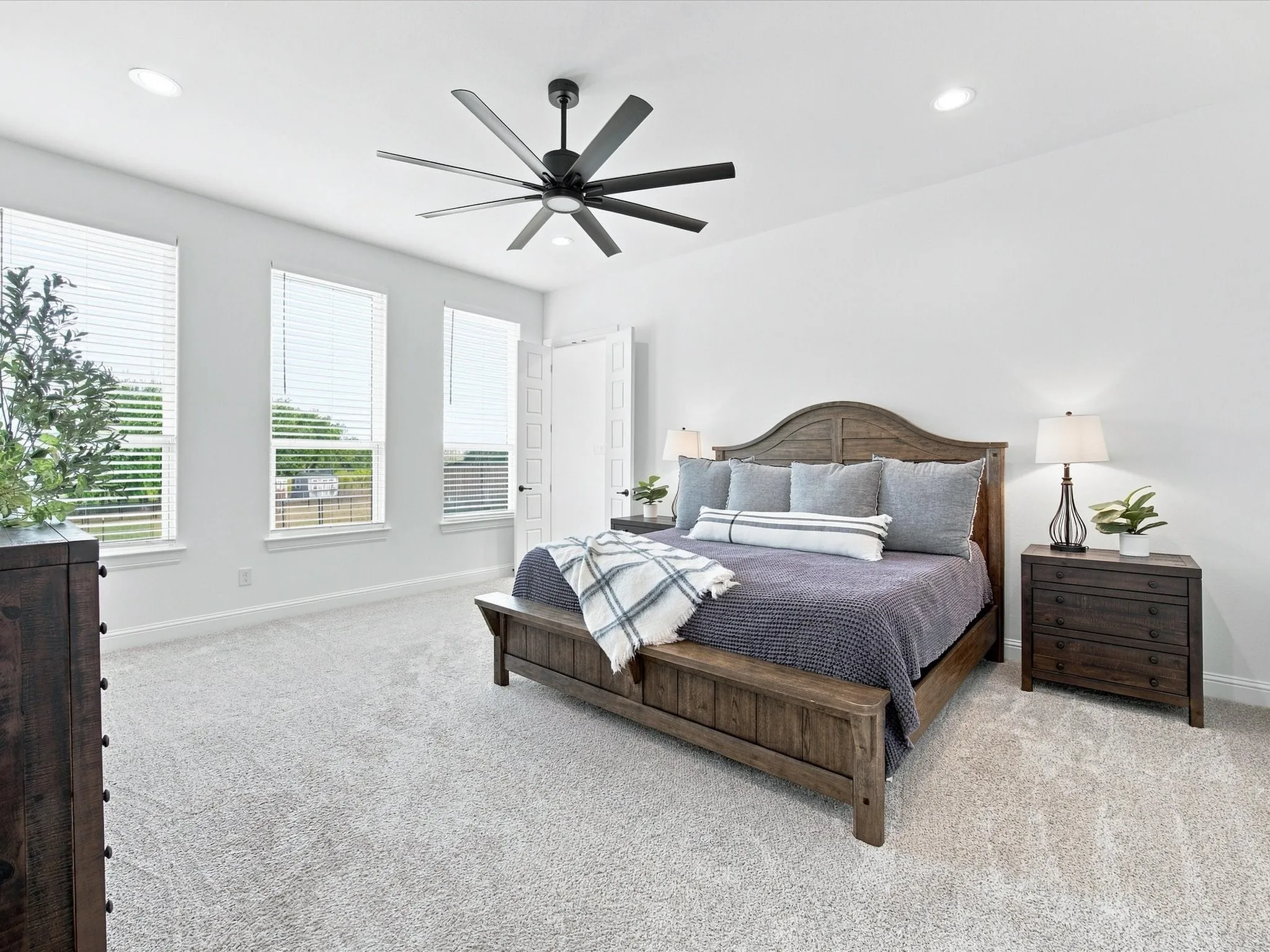 Recessed lighting, ceiling fan, multiple windows with blinds, light-toned carpeting, and a paneled door