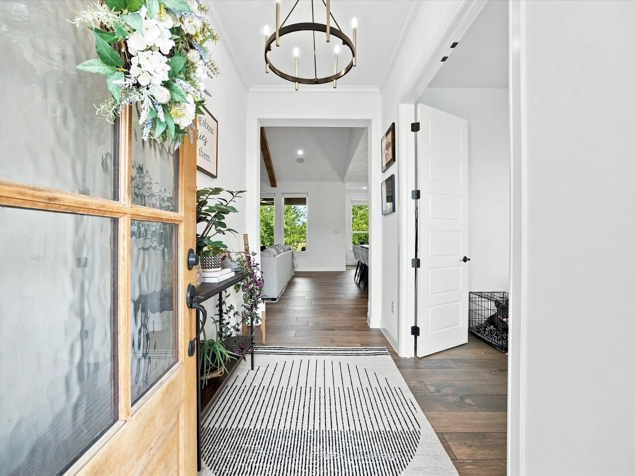 Wood-finish flooring throughout, with a recessed entry leading to an open living area