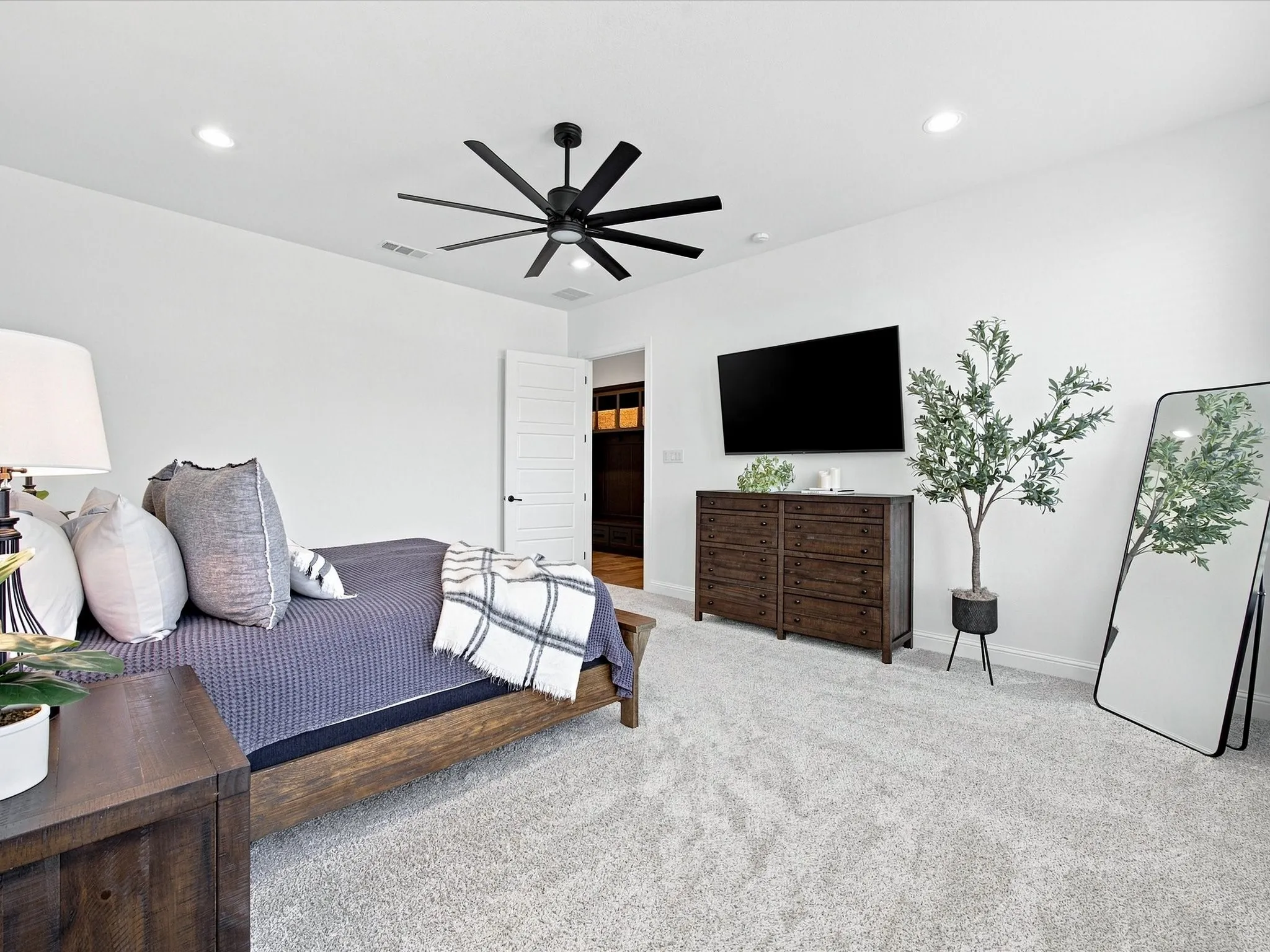 Recessed lighting, light gray carpeting, and a black multi-blade ceiling fan