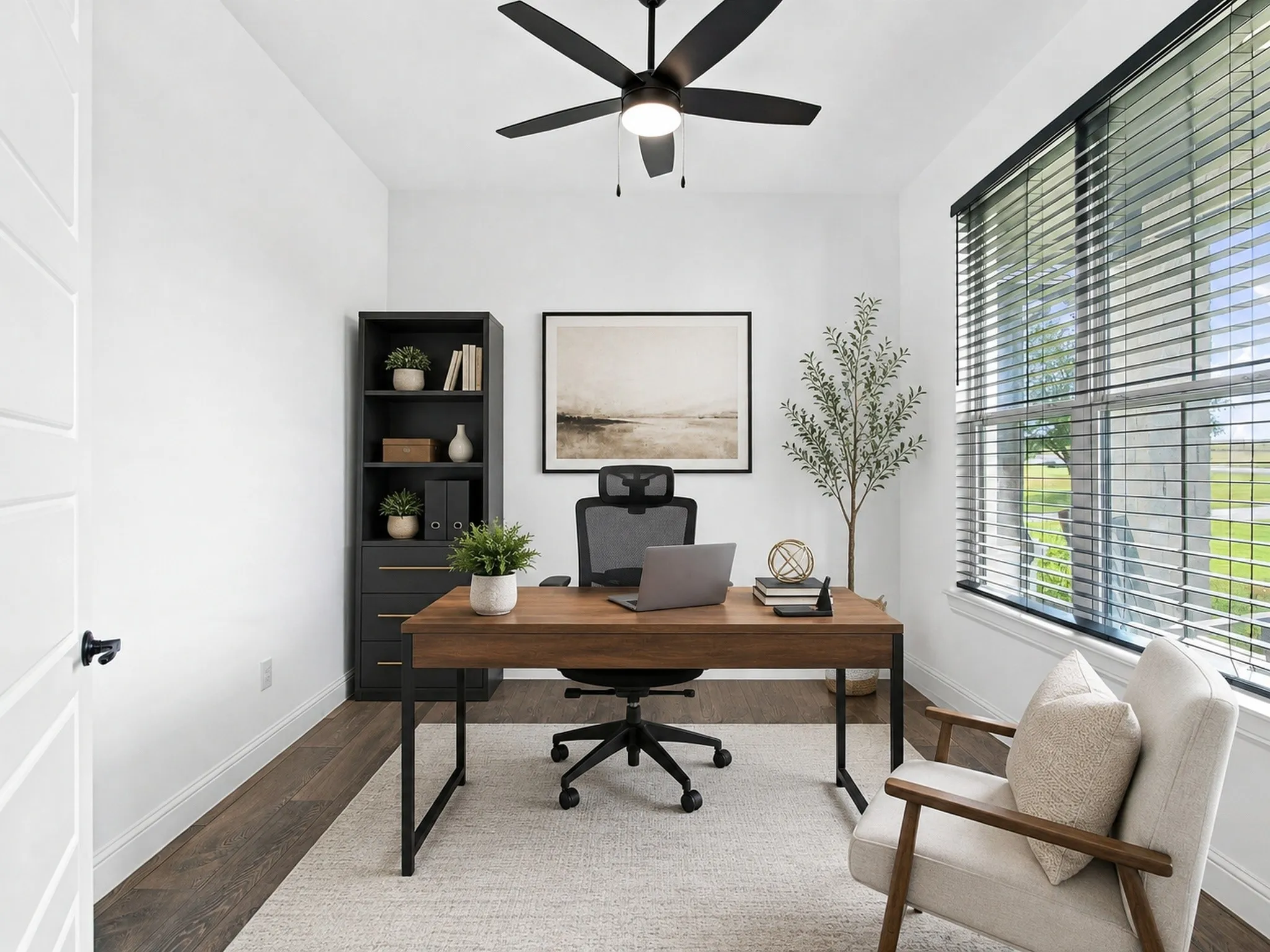 Virtually Staged! Home office featuring a wood-finish desk with metal legs, black task chair, and built-in shelving with adjustable shelves