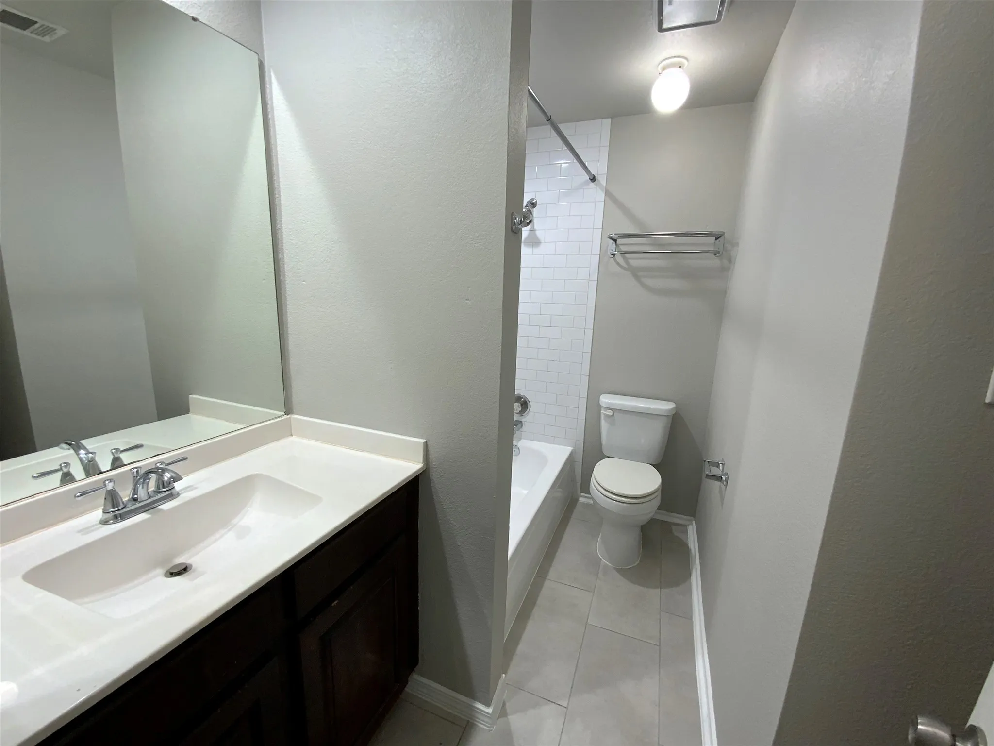 Bathroom vanity featuring a single basin sink and chrome faucet
