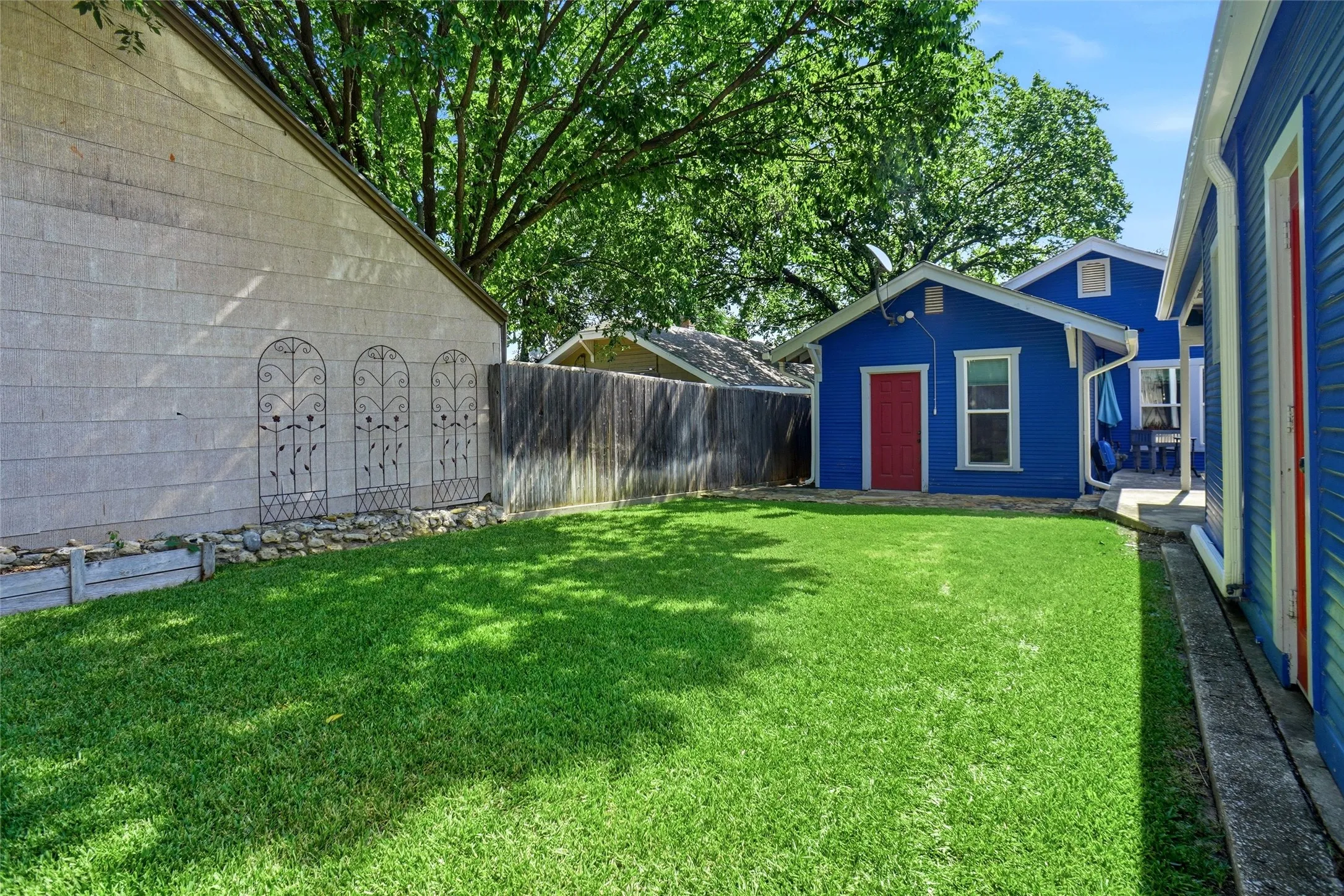 Expansive grassy yard with a wooden privacy fence