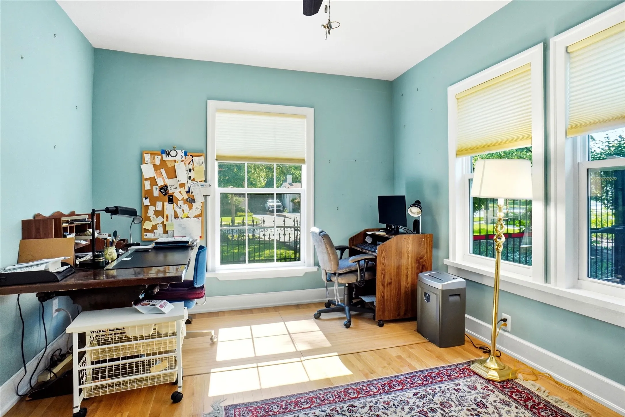 Bright room featuring multiple large windows with white trim, light blue walls, and wood-finish flooring