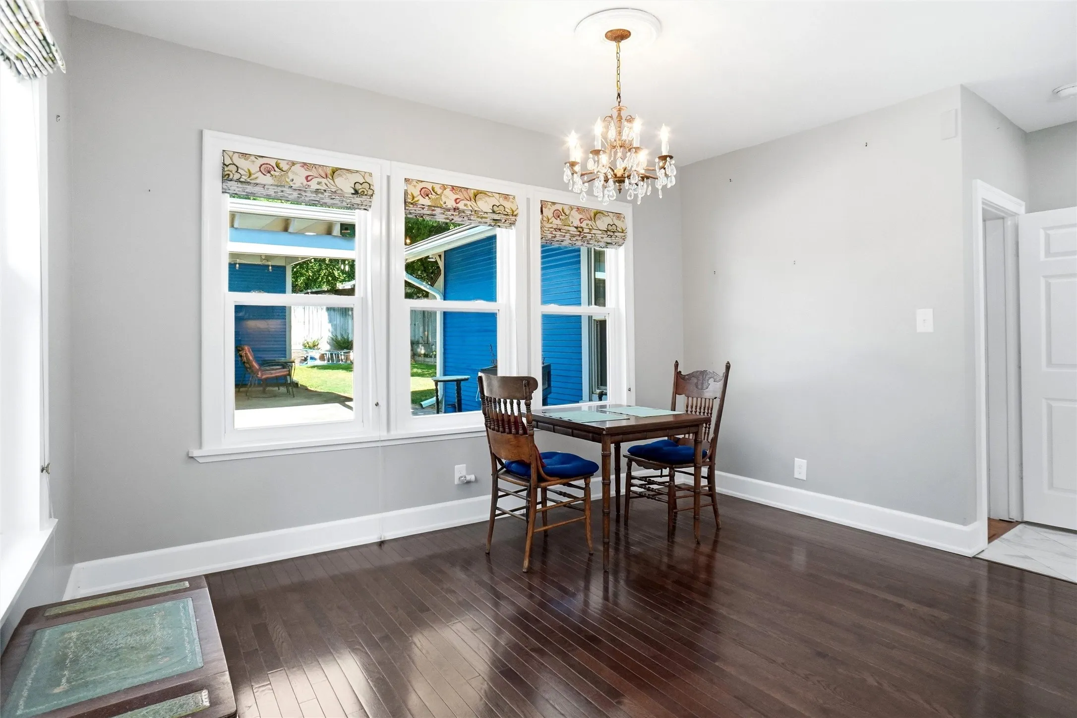Room featuring wood-finish flooring, light gray walls, and white trim