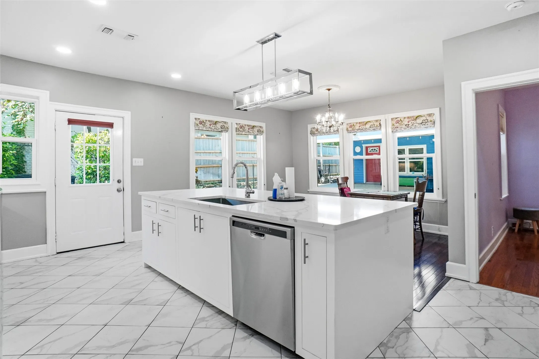 Kitchen featuring a large central island with a built-in sink and stainless-steel dishwasher