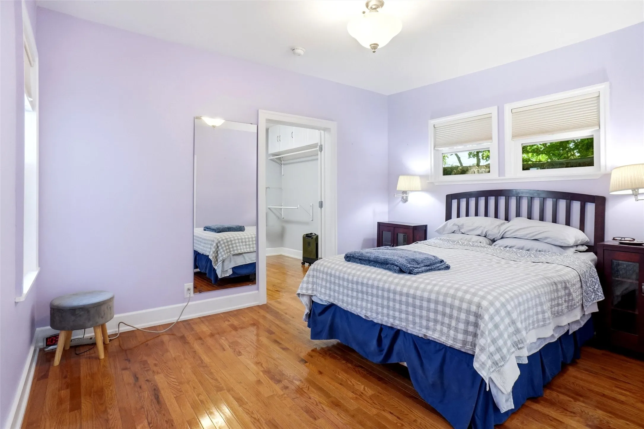 Hardwood flooring extending throughout, complemented by a light purple wall color