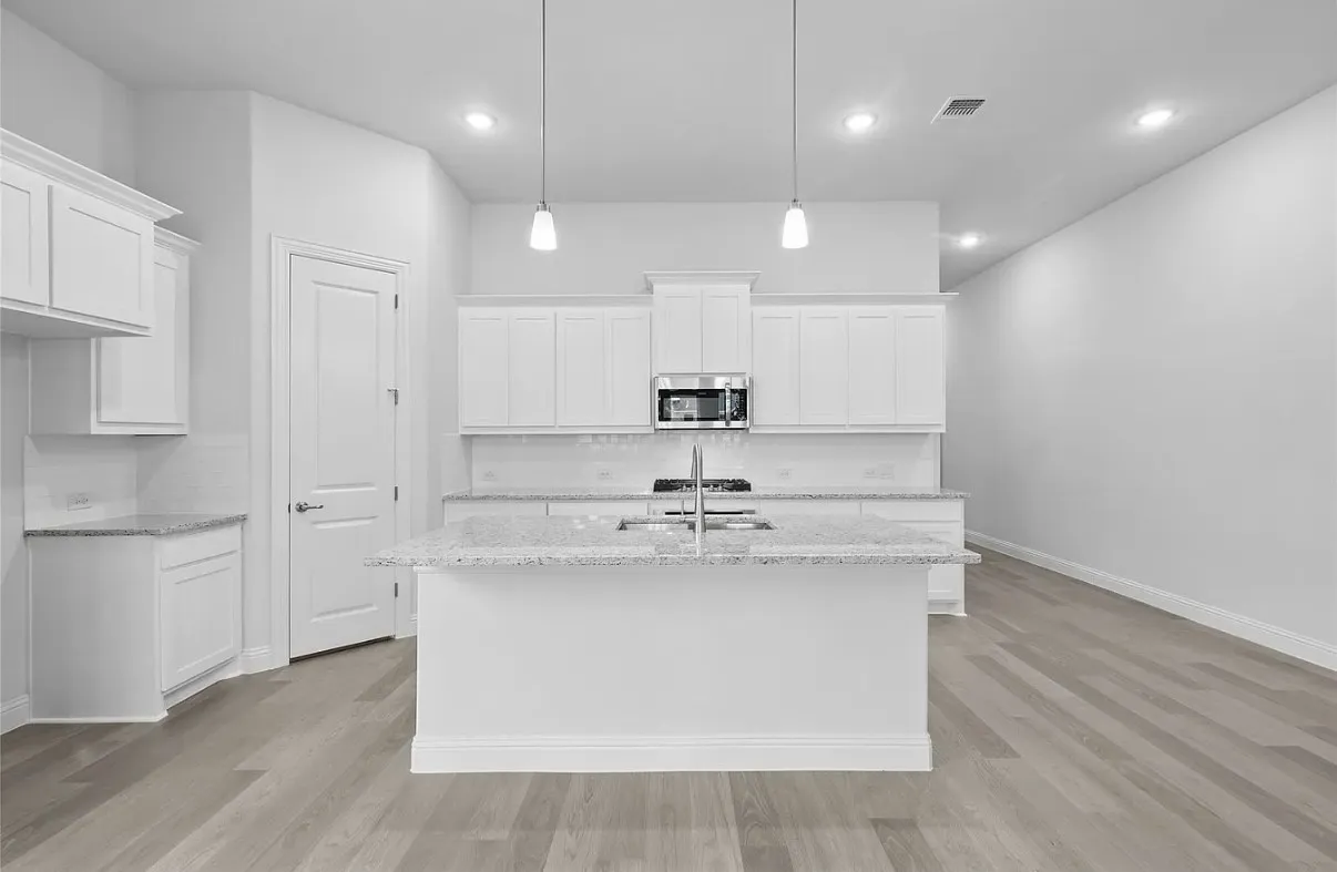 Modern kitchen featuring white cabinetry, light-toned wood-finish flooring, recessed lighting, and a kitchen island with pendant lighting