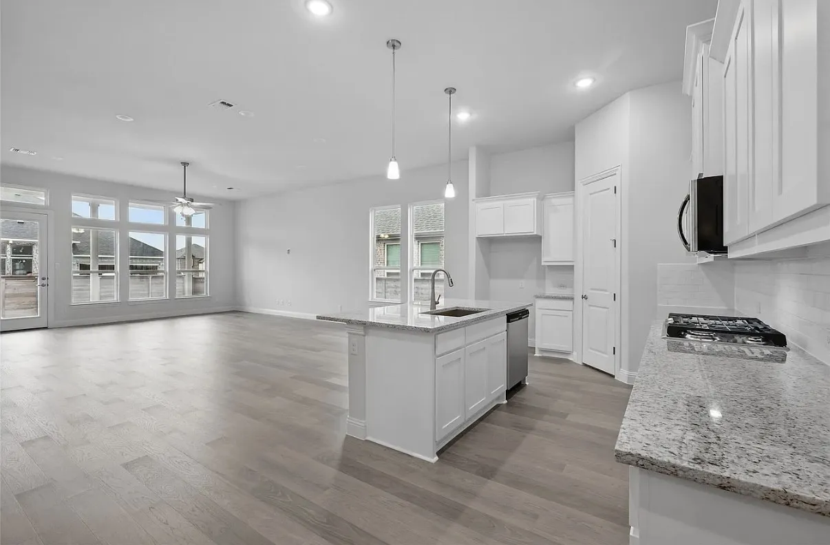 Open-concept living area with wood-finish flooring, recessed lighting, and a ceiling fan