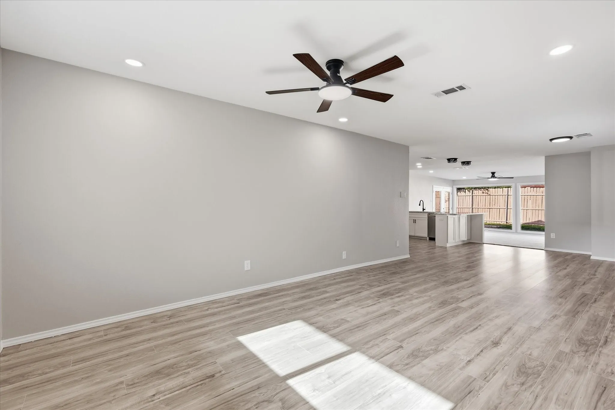 Spacious interior featuring wood-finish flooring, recessed lighting, and a contemporary ceiling fan