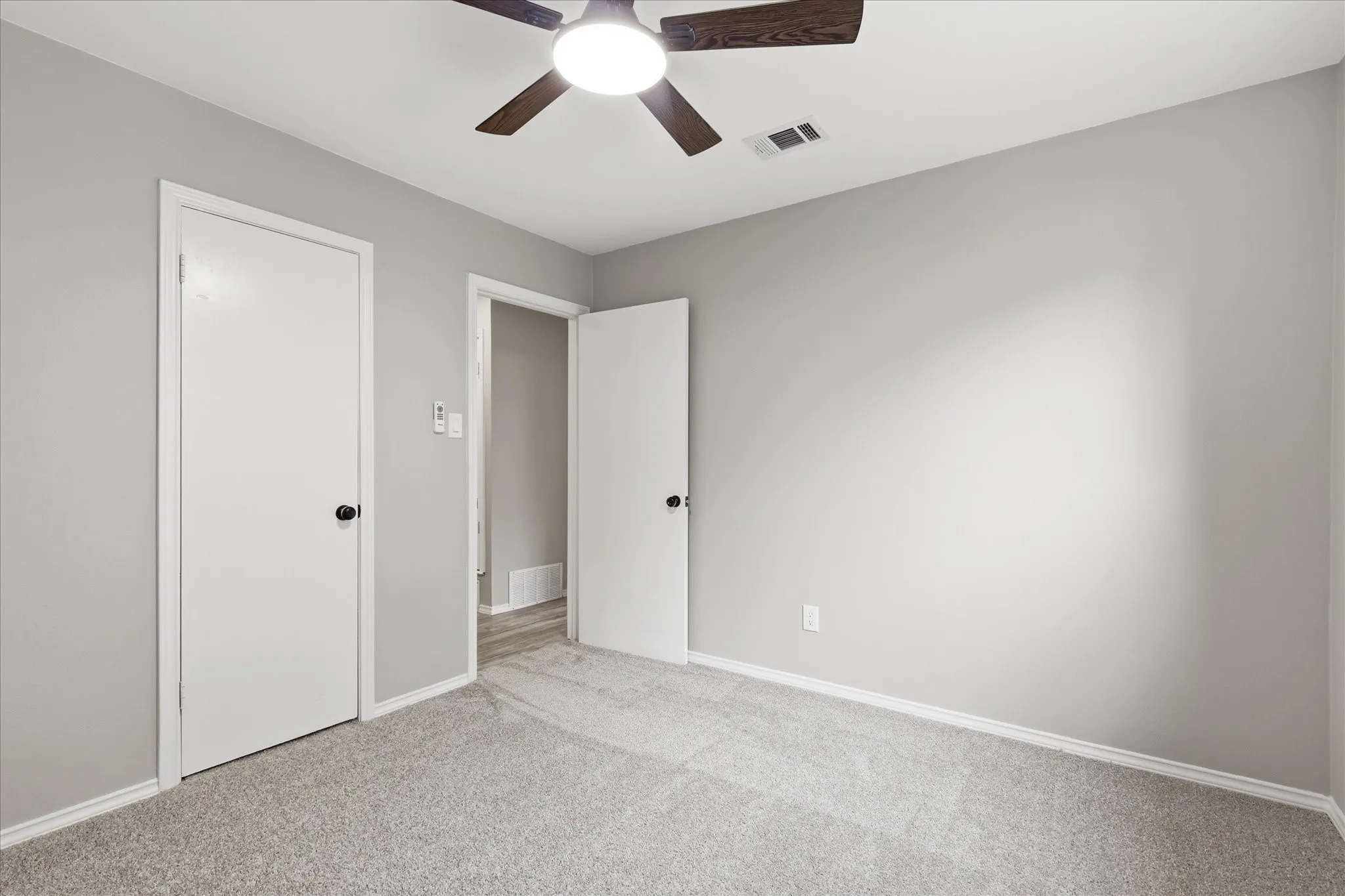 Room featuring neutral gray walls, light gray carpeting, and white trim