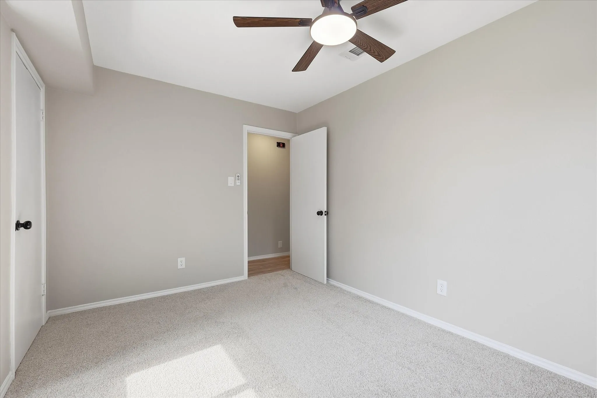 Neutral-toned room with light beige carpeting and white baseboards