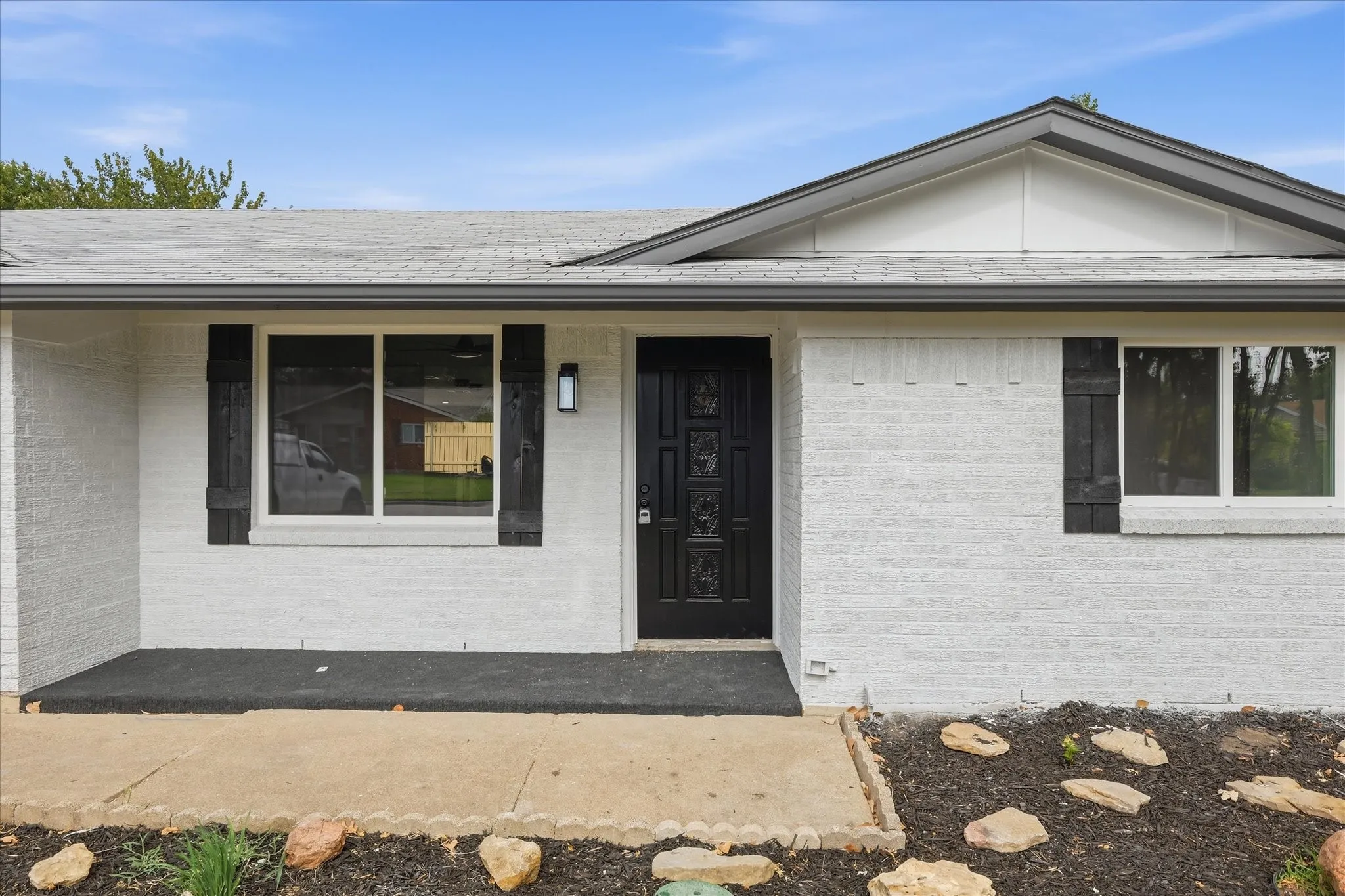 White painted brick exterior with dark trim and accents