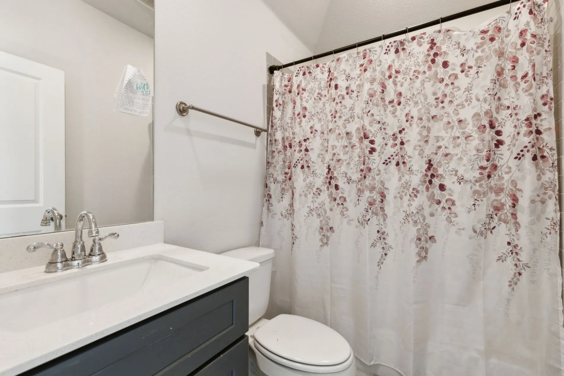 Bathroom vanity with a white countertop and undermount sink, complemented by a polished chrome faucet