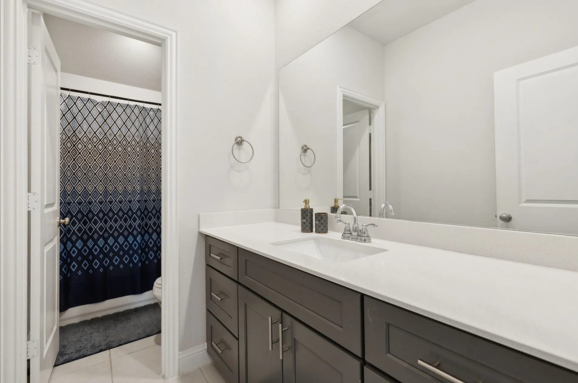 Bathroom vanity featuring a single-basin sink, chrome faucet, and expansive countertop