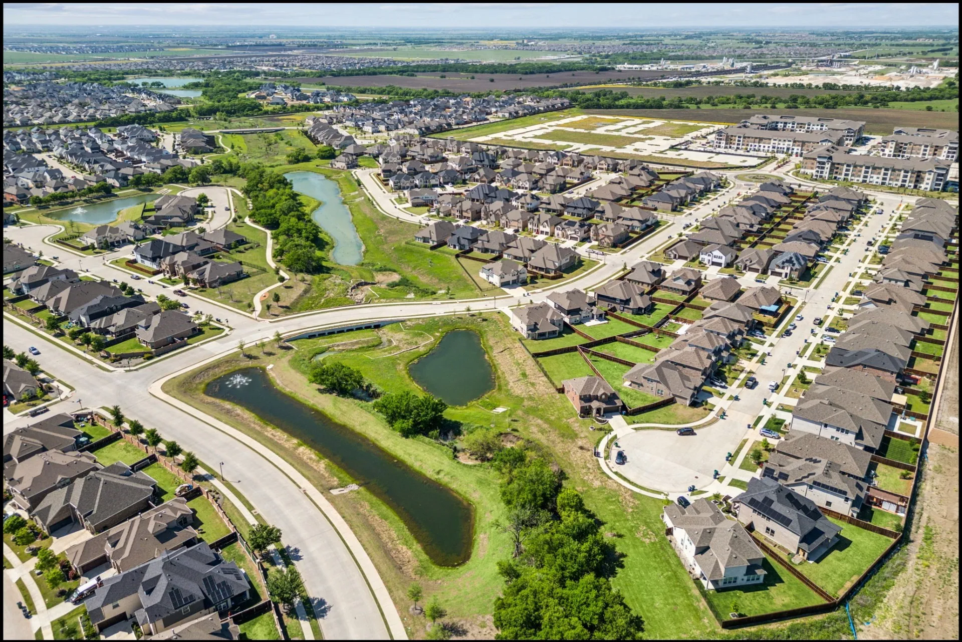 Developed residential neighborhood featuring single-family homes, paved roads, and landscaped common areas