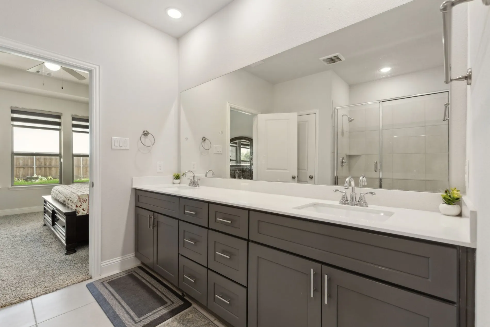 Double vanity with gray cabinetry, white countertops, and chrome fixtures