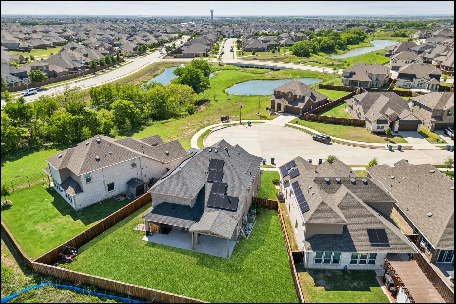 Aerial perspective showcasing a residential development with a prominent property featuring multiple solar panels