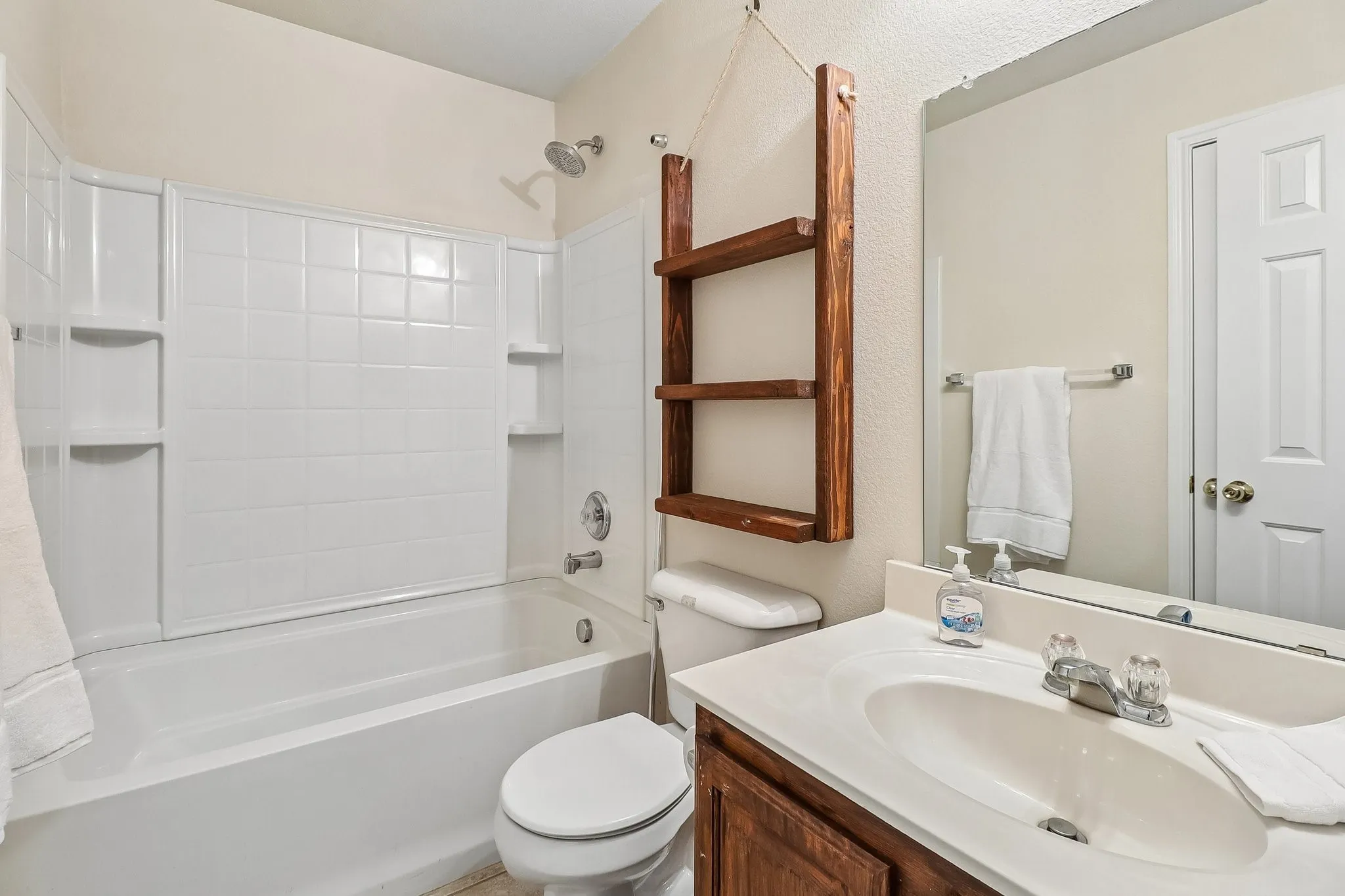 Bathroom featuring a white tub and shower combination with an integrated tile-patterned surround