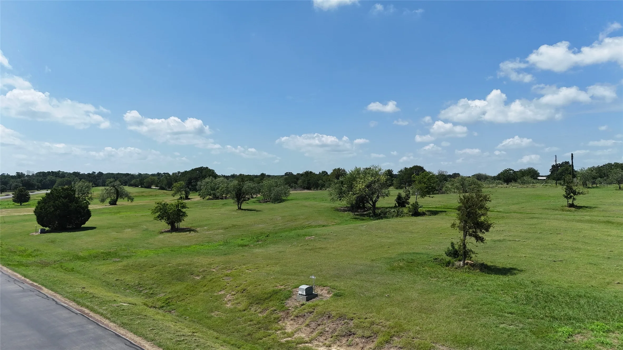 Cleared homesite with scattered trees ready for your custom lake-area home.