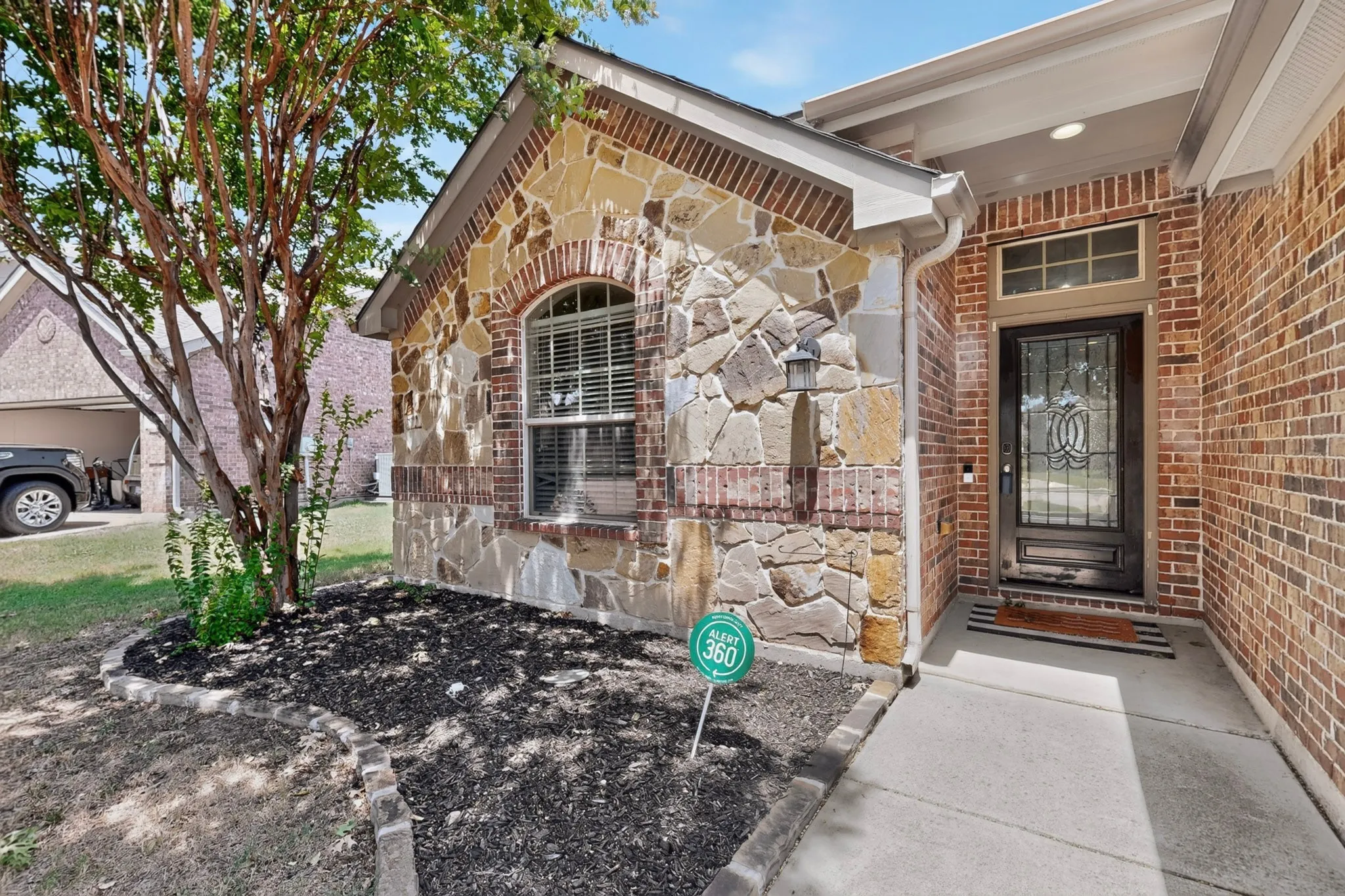 Brick and stone veneer facade with an arched window