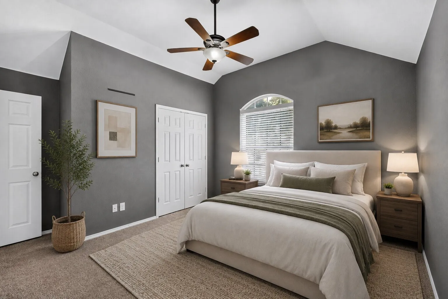 Vaulted ceiling, ceiling fan with light fixture, arched window with blinds, panel doors, and carpet flooring