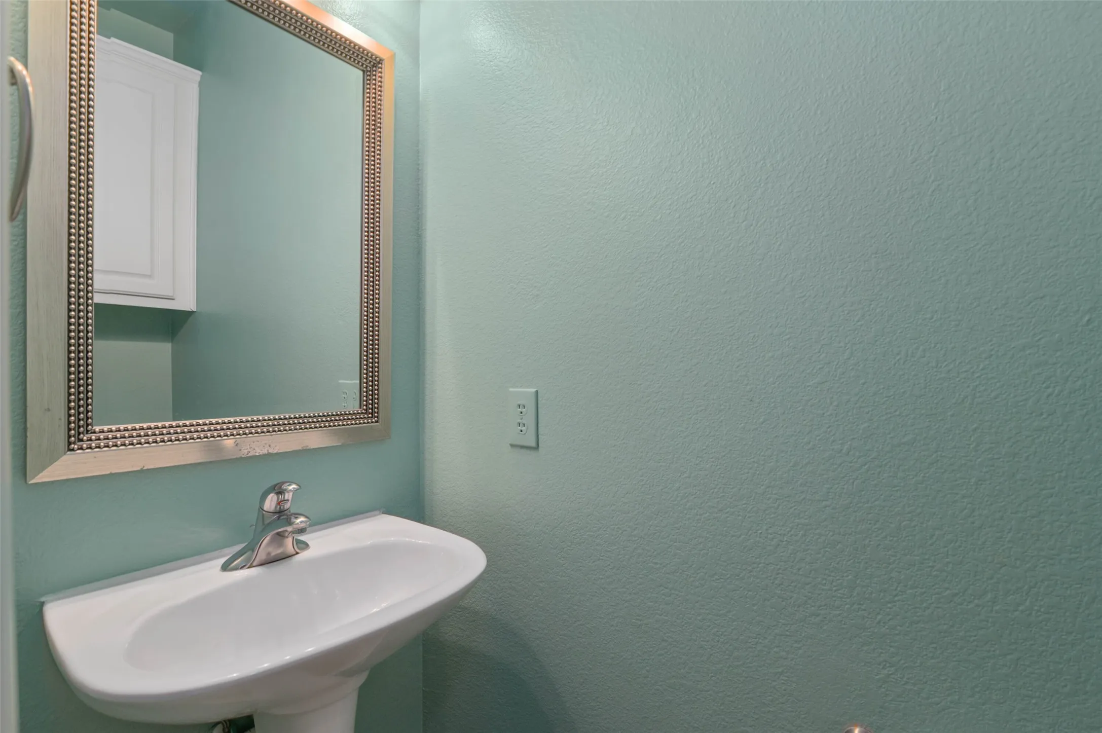 Half bathroom off the utility room and primary bedroom wing.