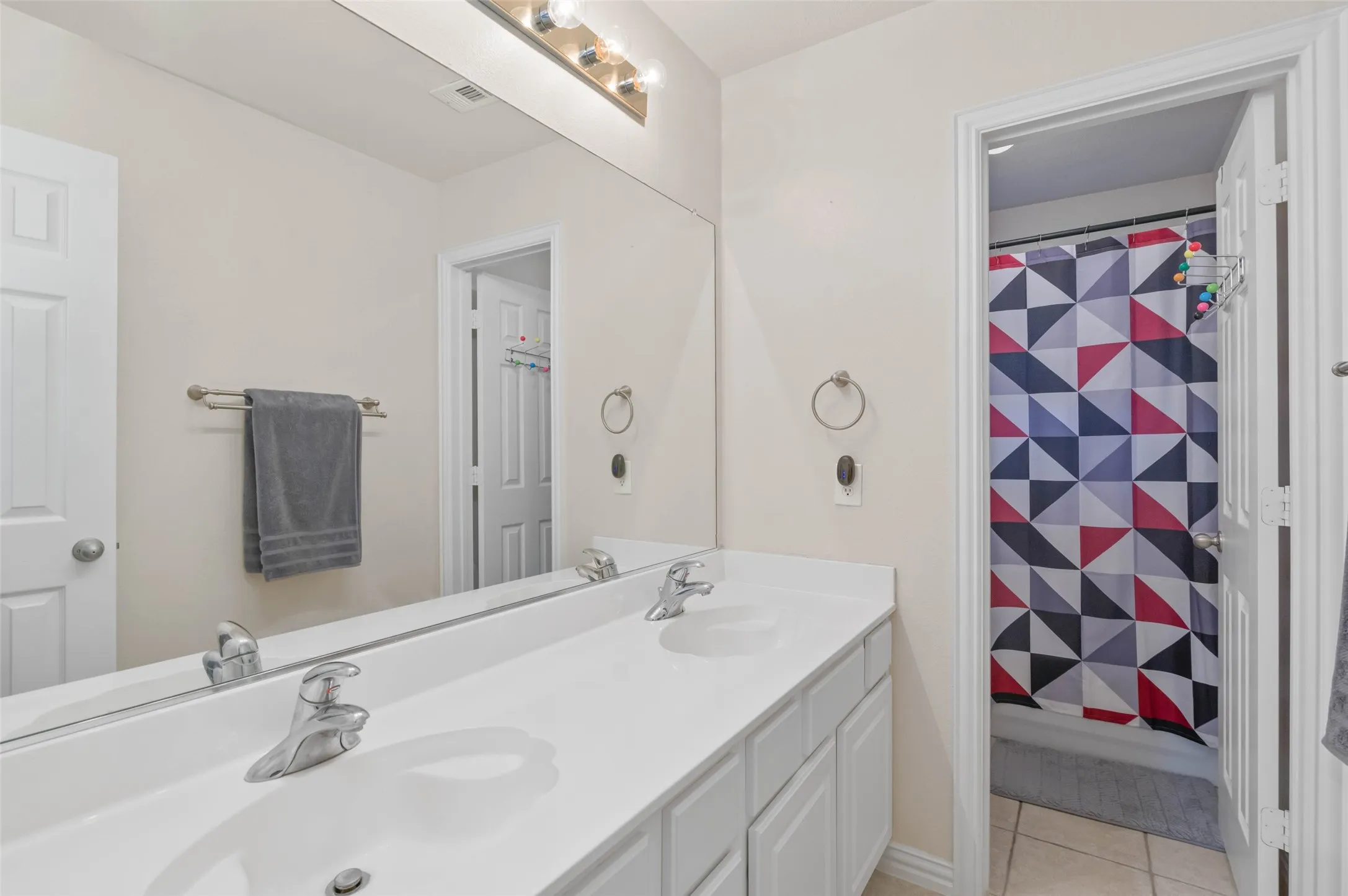 Upstairs full bathroom with dual sinks.